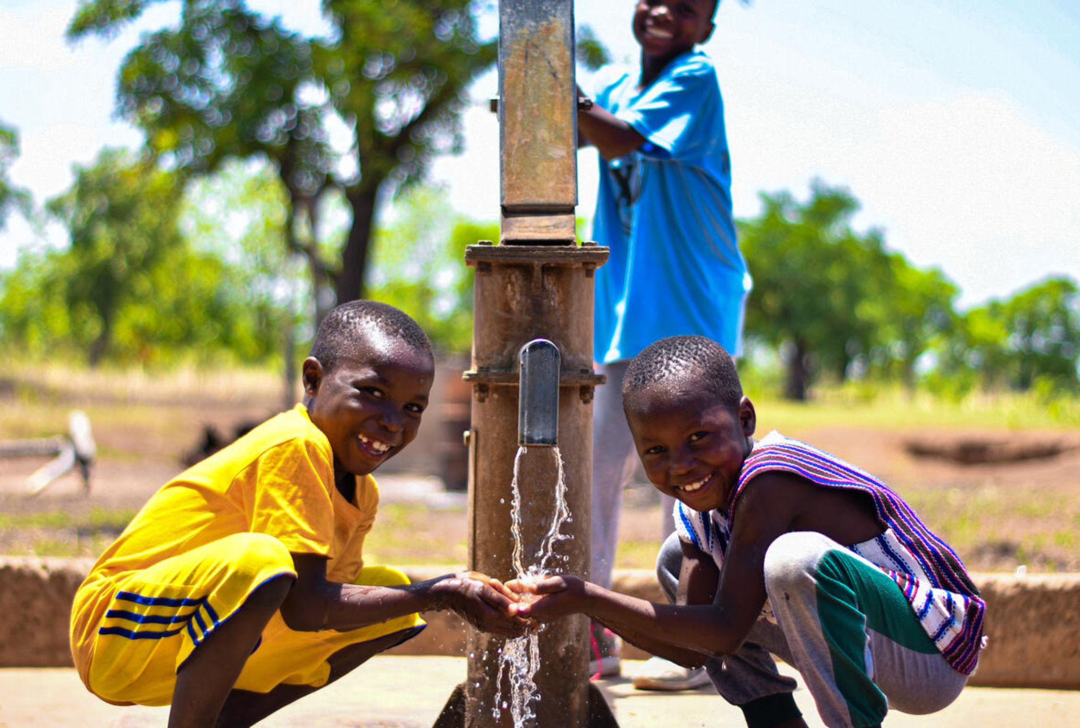 Happy children accessing water from a World Vision-drilled borehole in Ghana