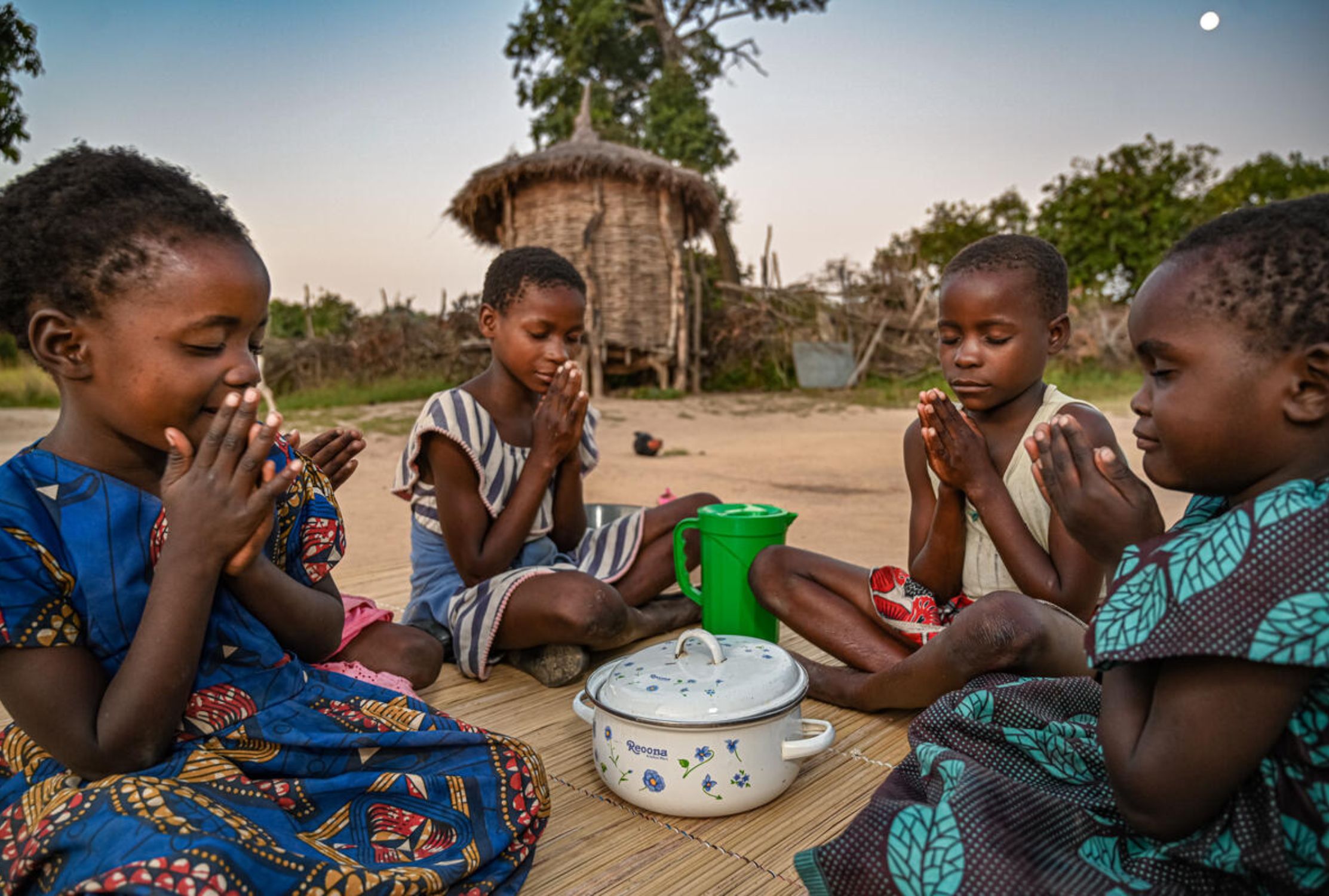 Zambian children praying before eating