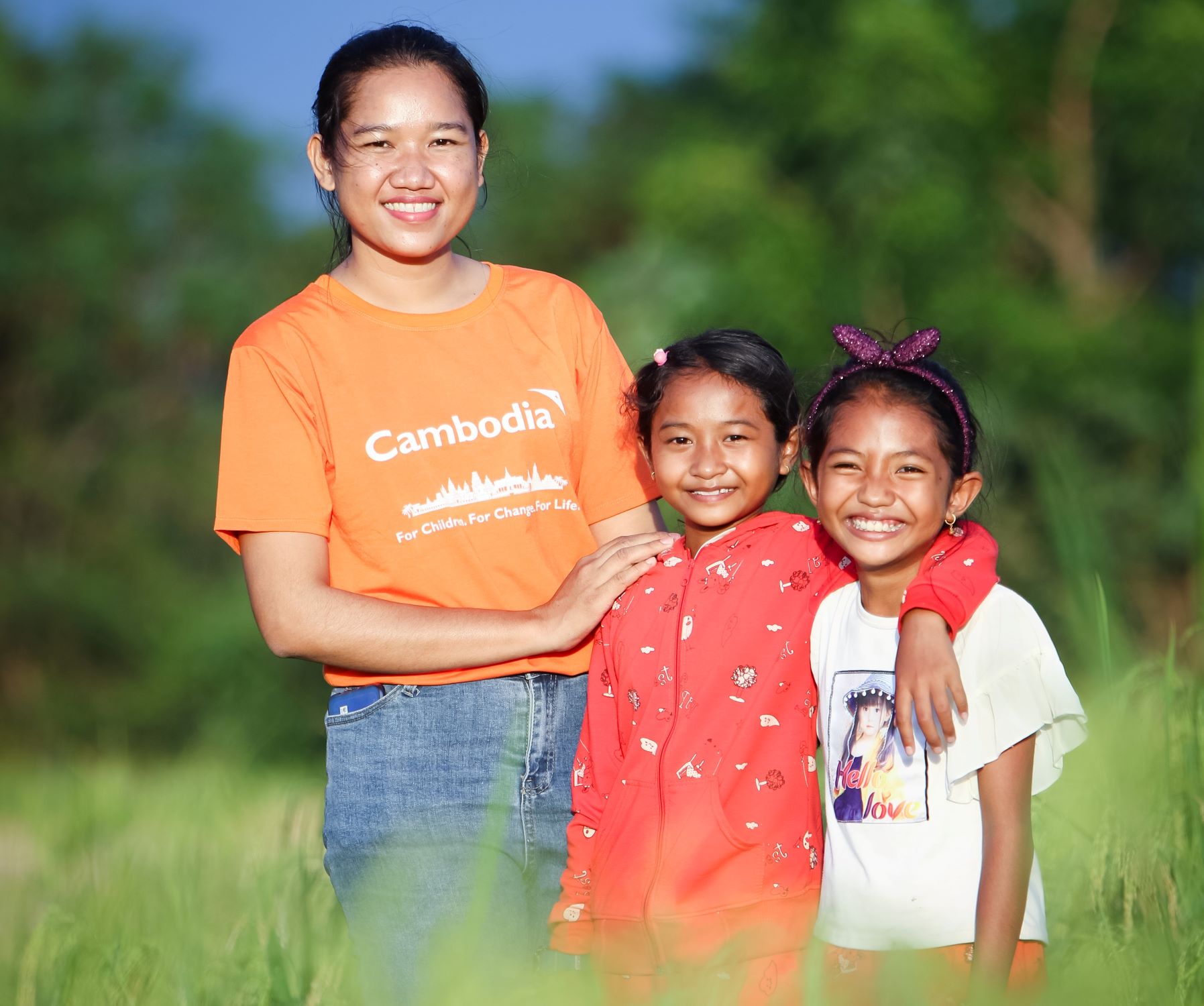 Lady with World Vision Cambodia T-shirt and two children smiling