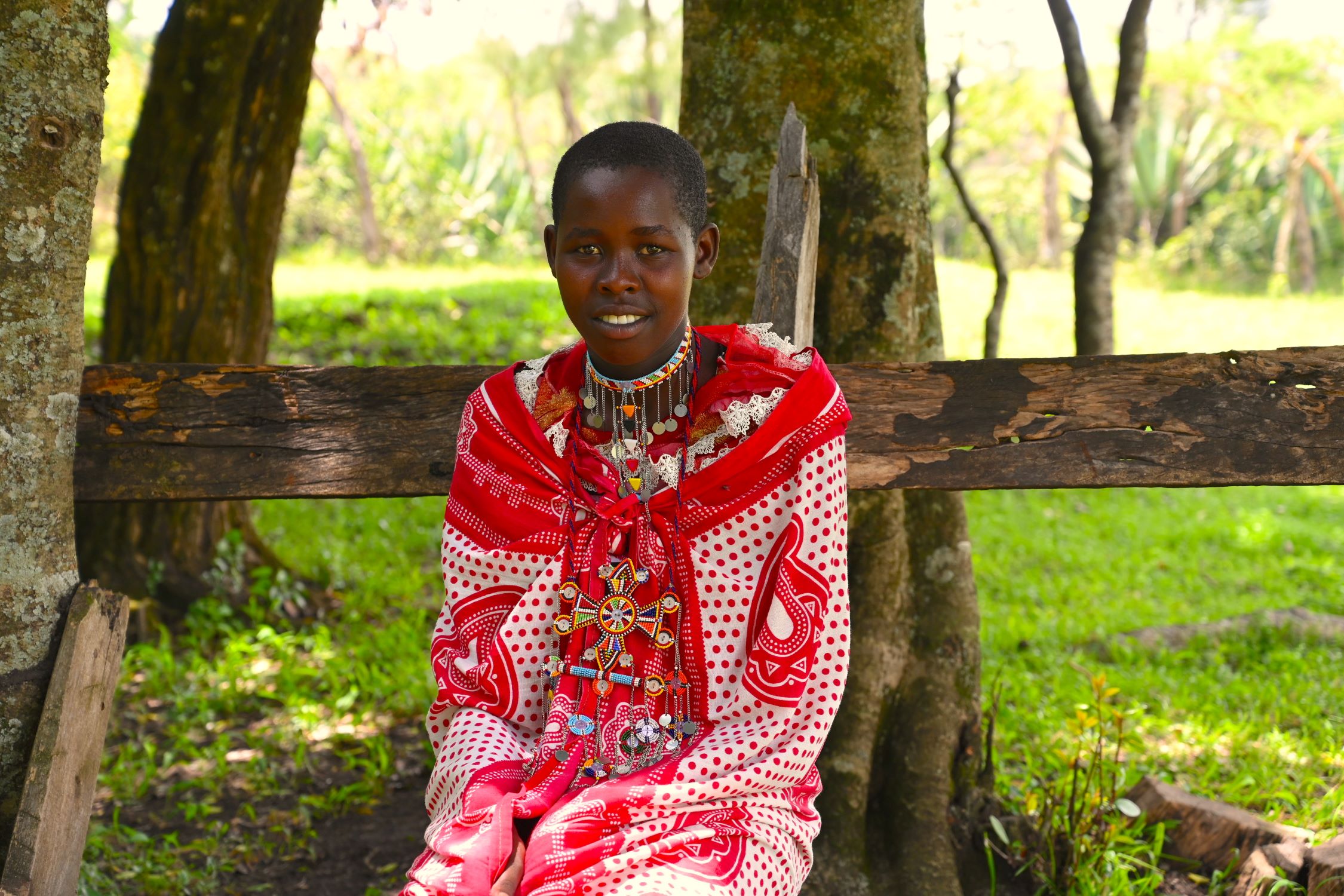 Kenyan teen smiling, dressed in traditional red