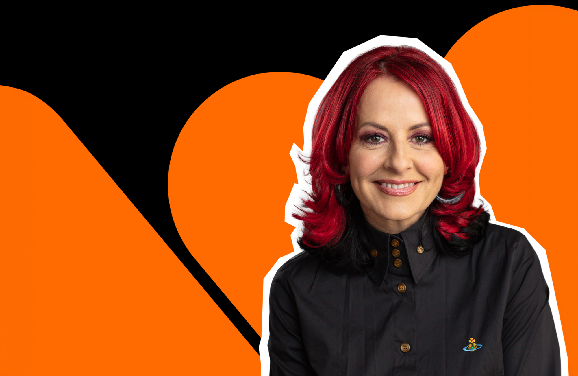 Carrie Grant smiles to camera in front of a orange and black background