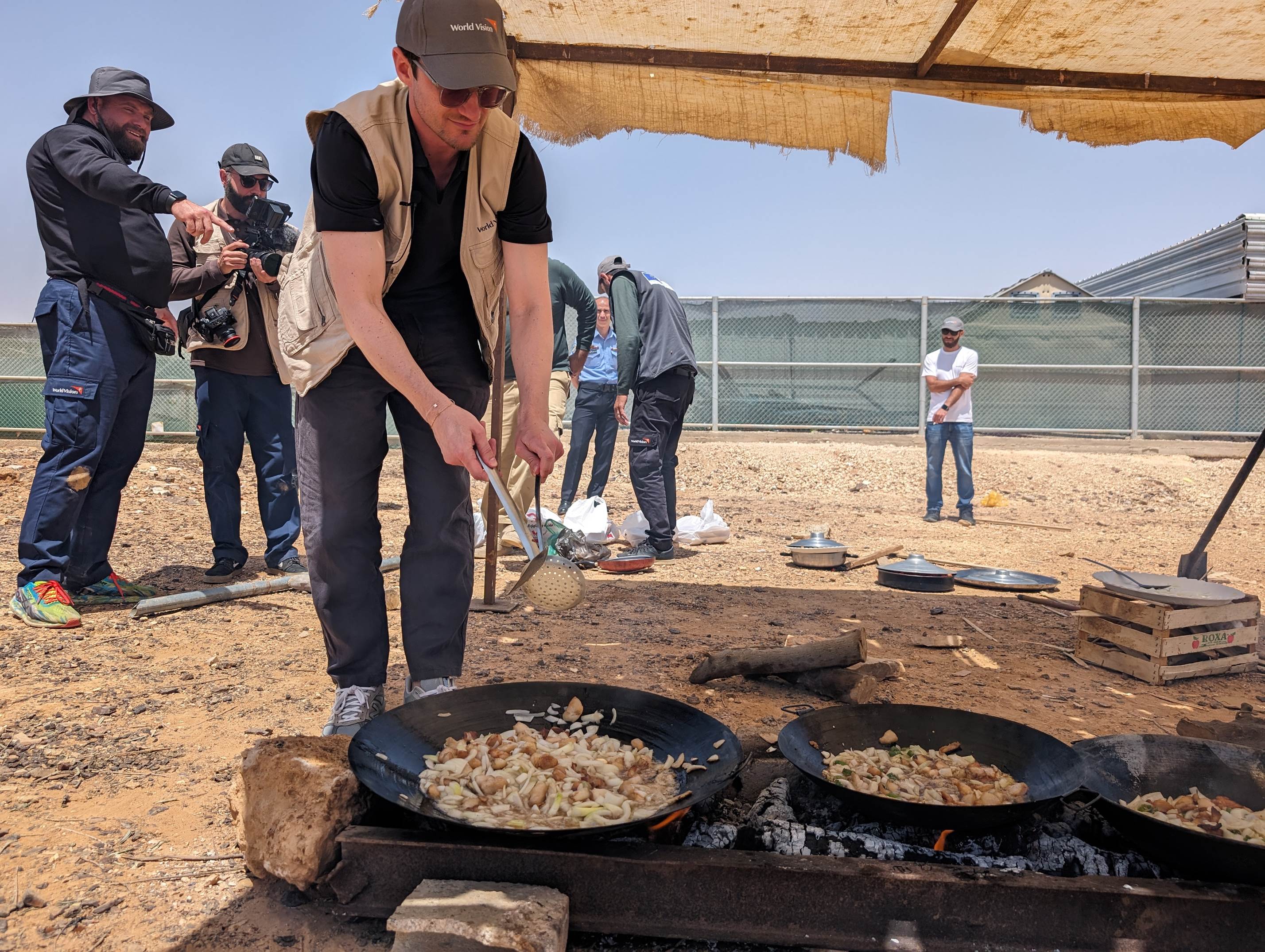 Brett stands over an outdoor cooking stove 