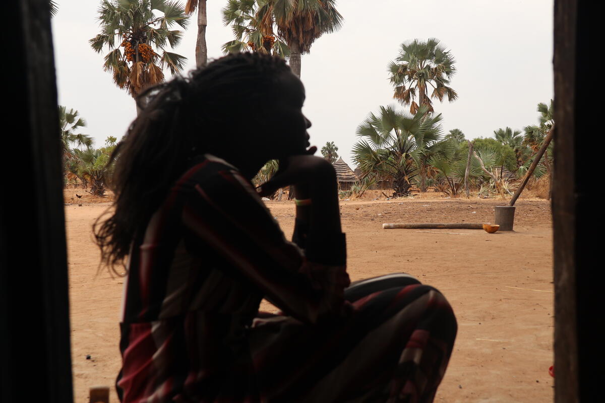 Silhouette of a girl from South Sudan sat facing to the side 