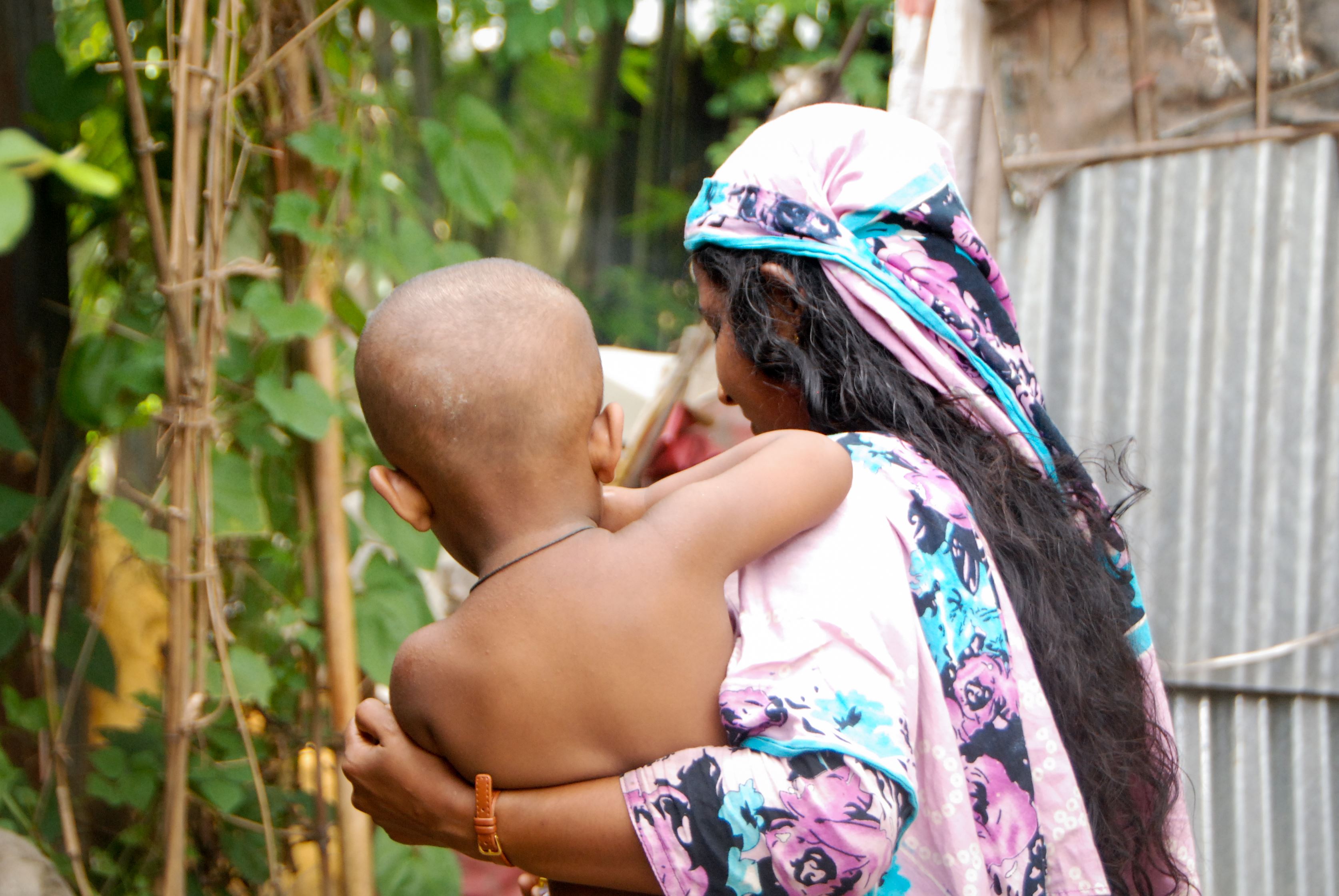 Mother and child walking away from camera in Bangladesh