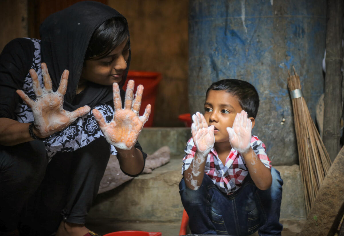 Child's mother teaches him the right way to wash his hands at home in Bangladesh