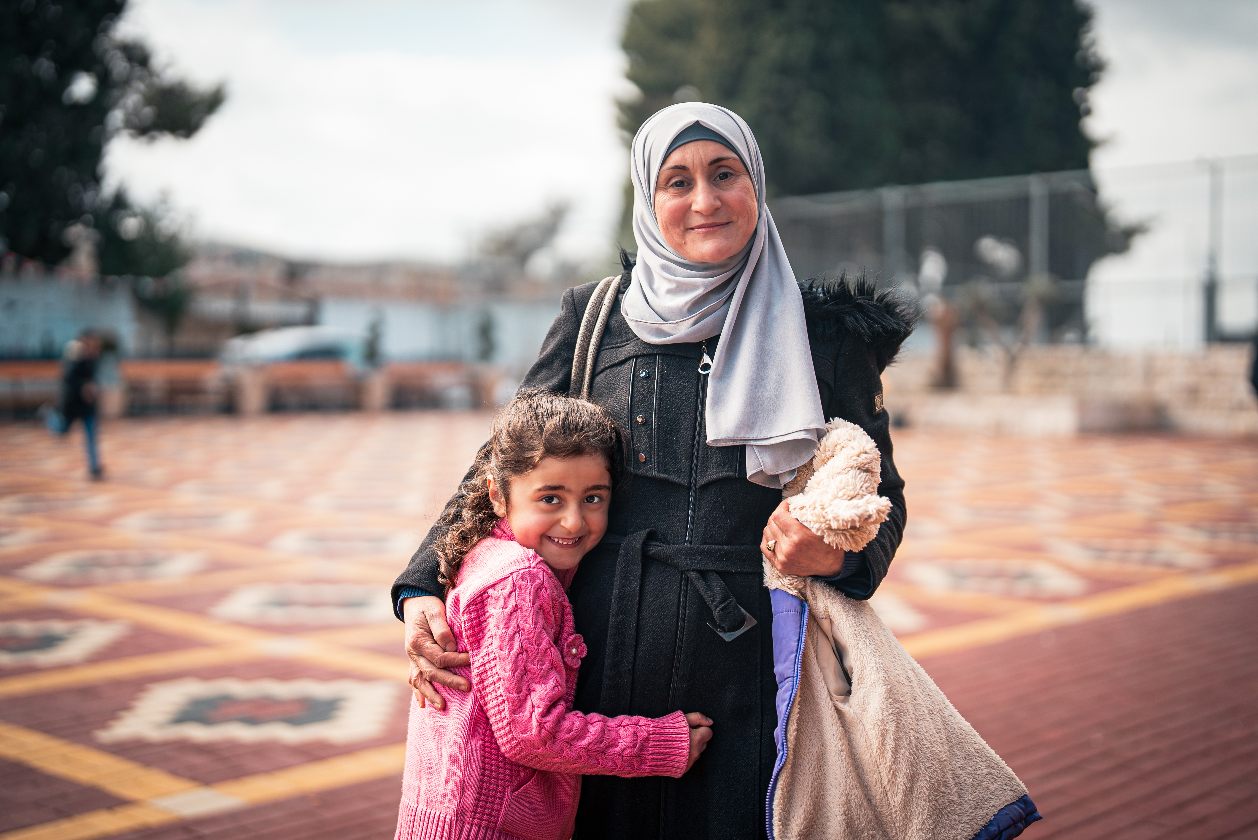 A young girl in the West Bank hugs her mother