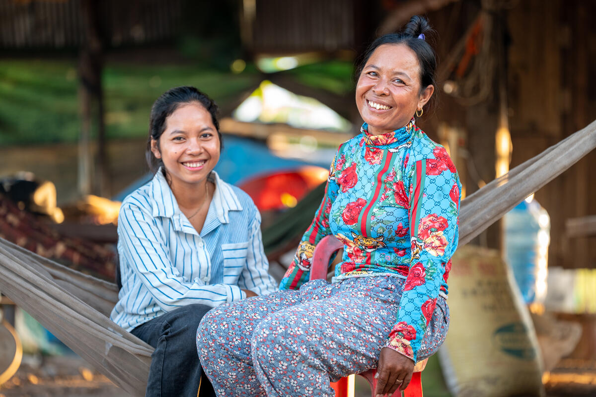 Cambodian sponsored girl sat with her mother, both smiling
