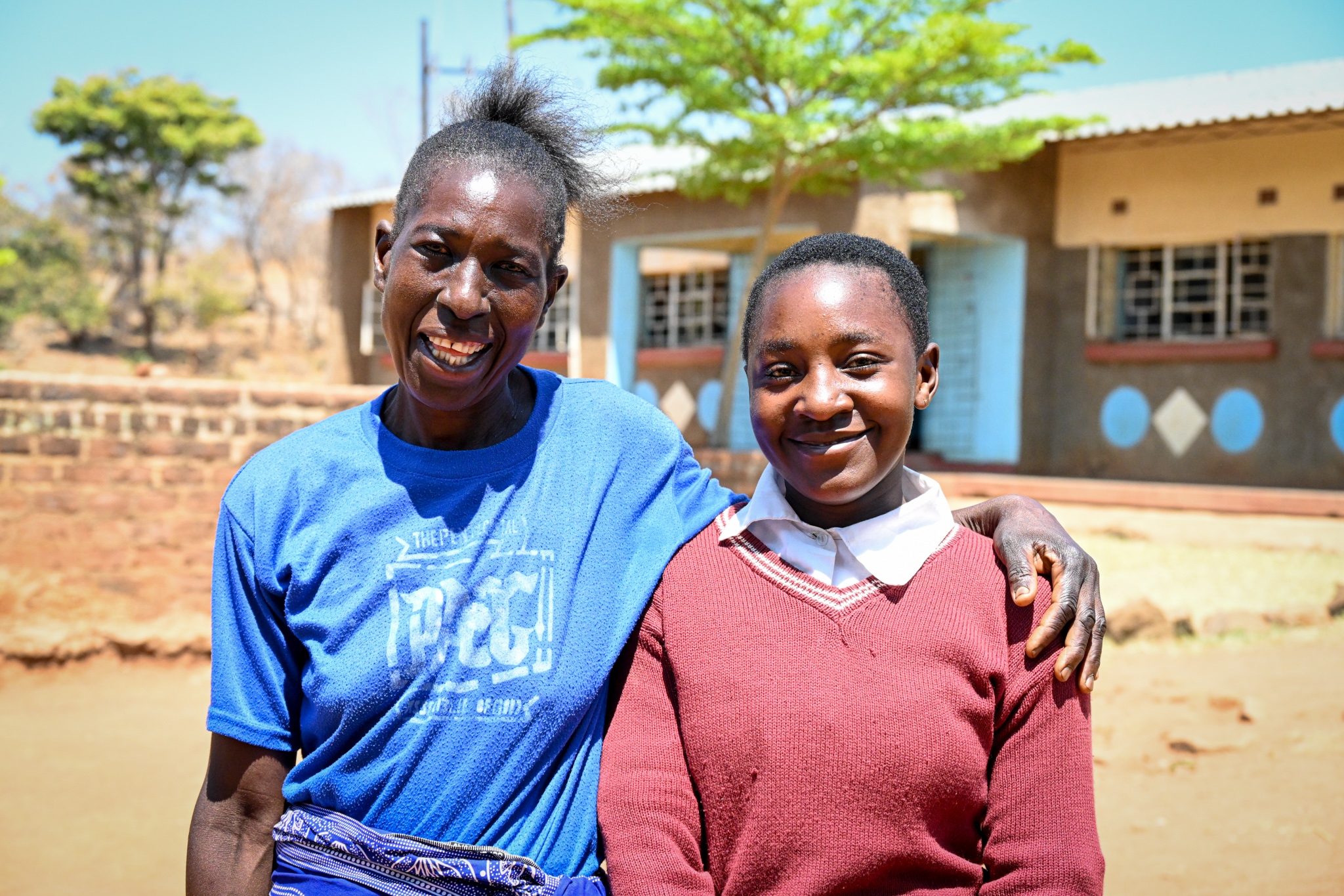 Joyce stands with a female pupil from the school she founded - both smile contentedly