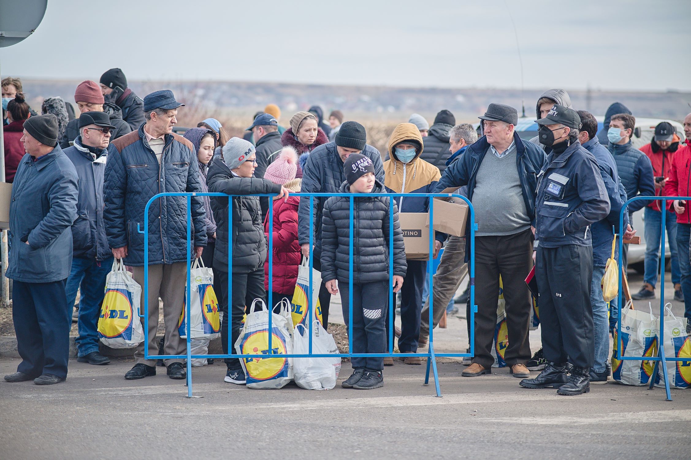 Ukrainian people are seeking refuge in Romania, pictured with luggage behind a barrier
