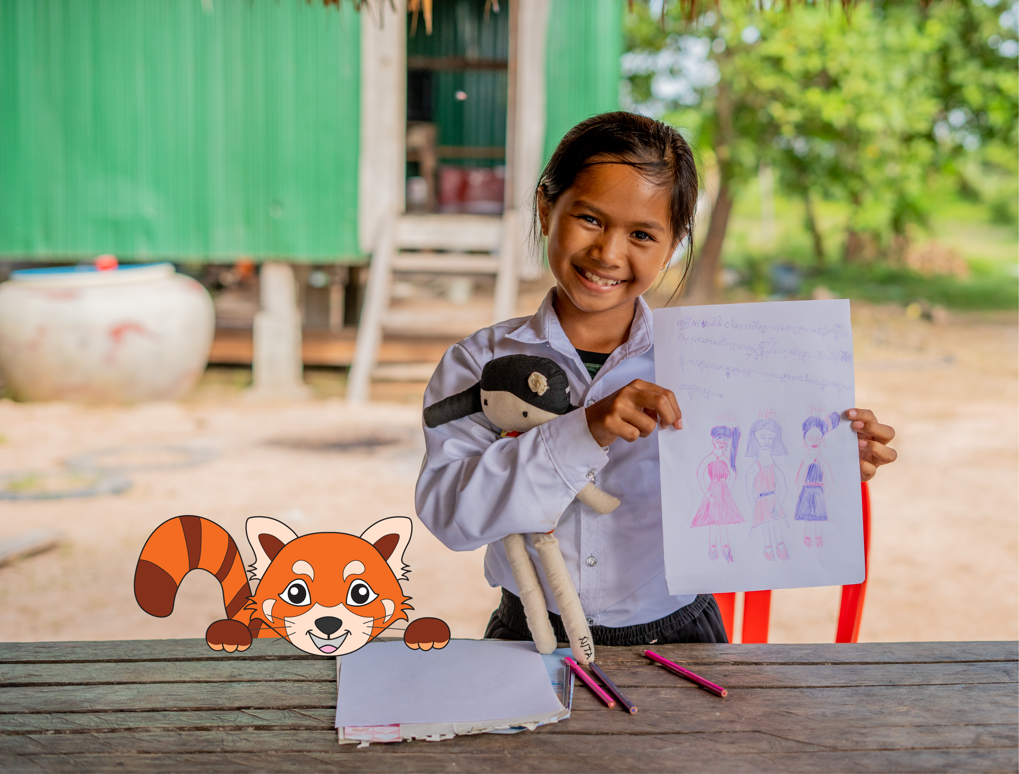 Young girl from Cambodia holding an educational worksheet up and smiling to the camera