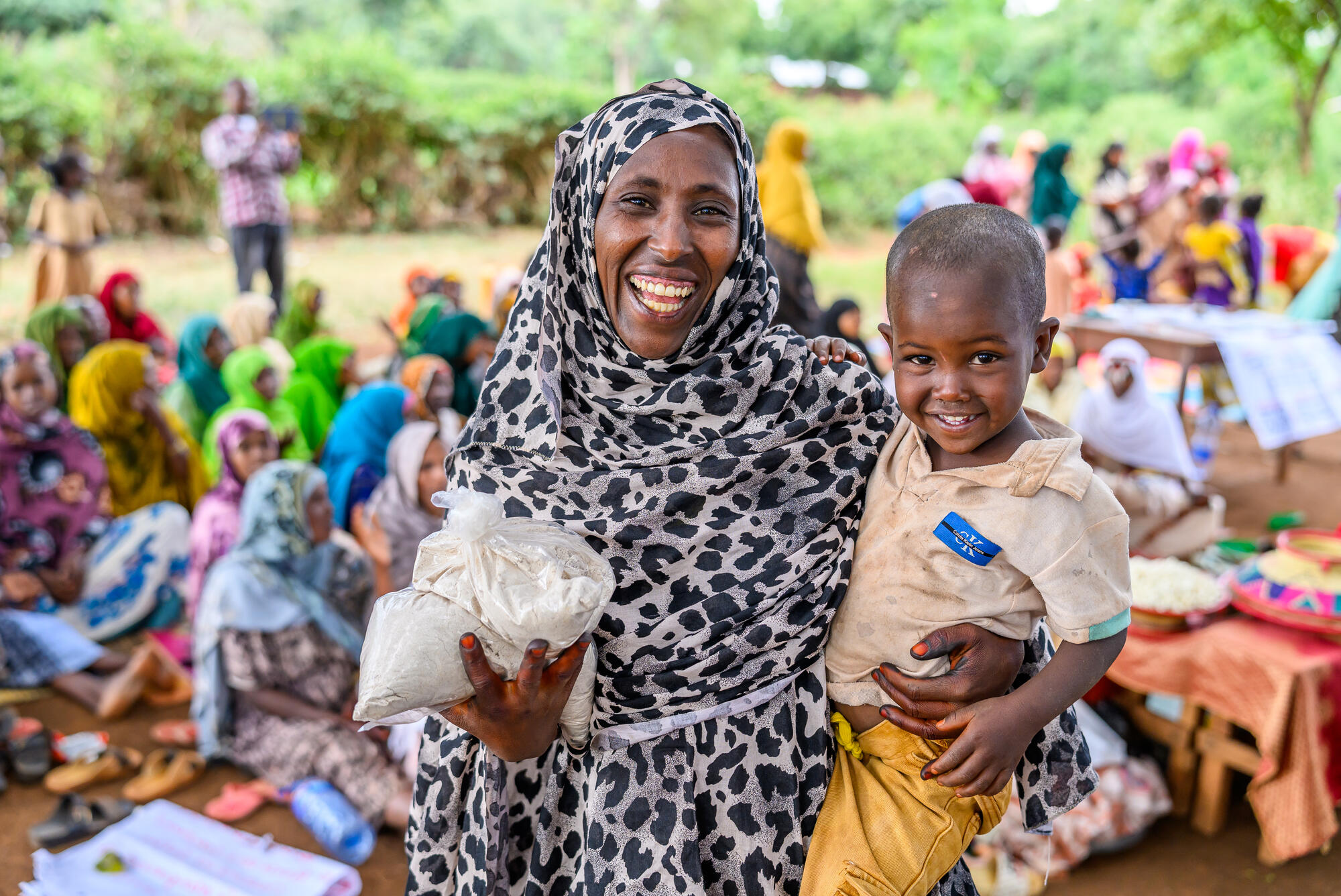 Two young children, dressed warmly, smile to the camera.