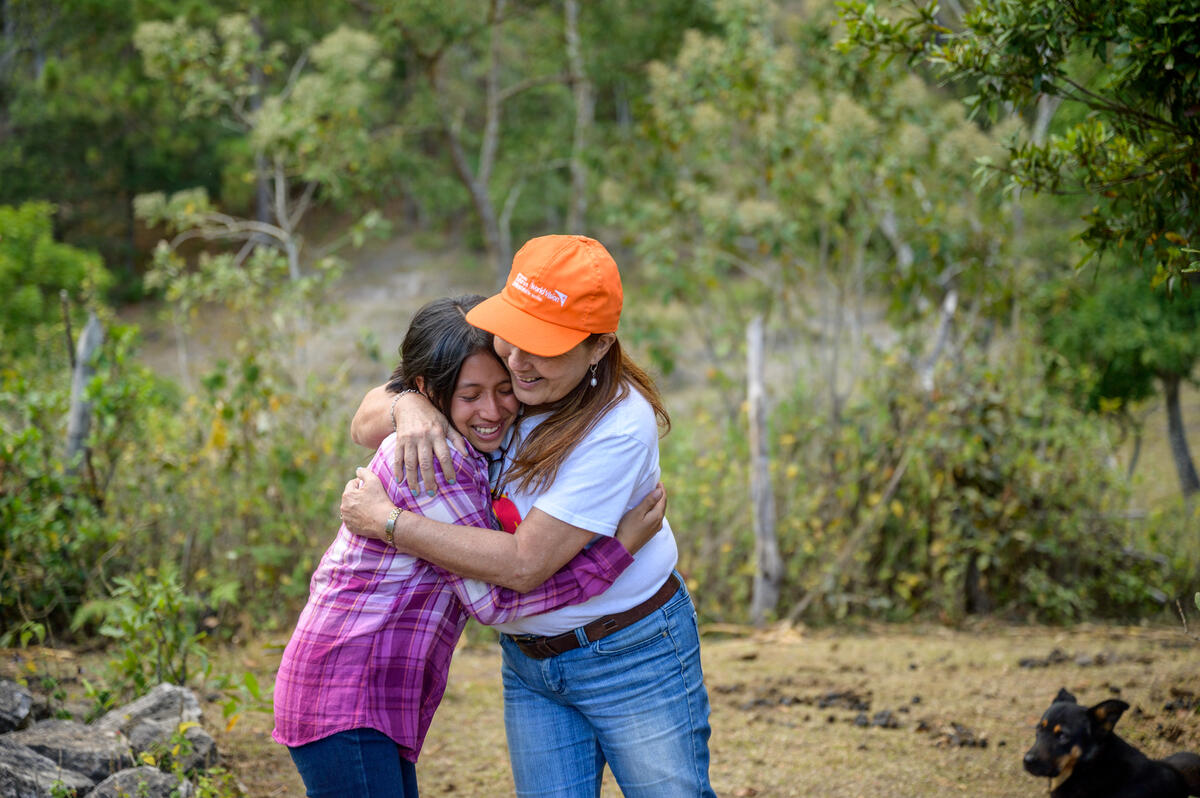 Staff member hugs girl in Honduras