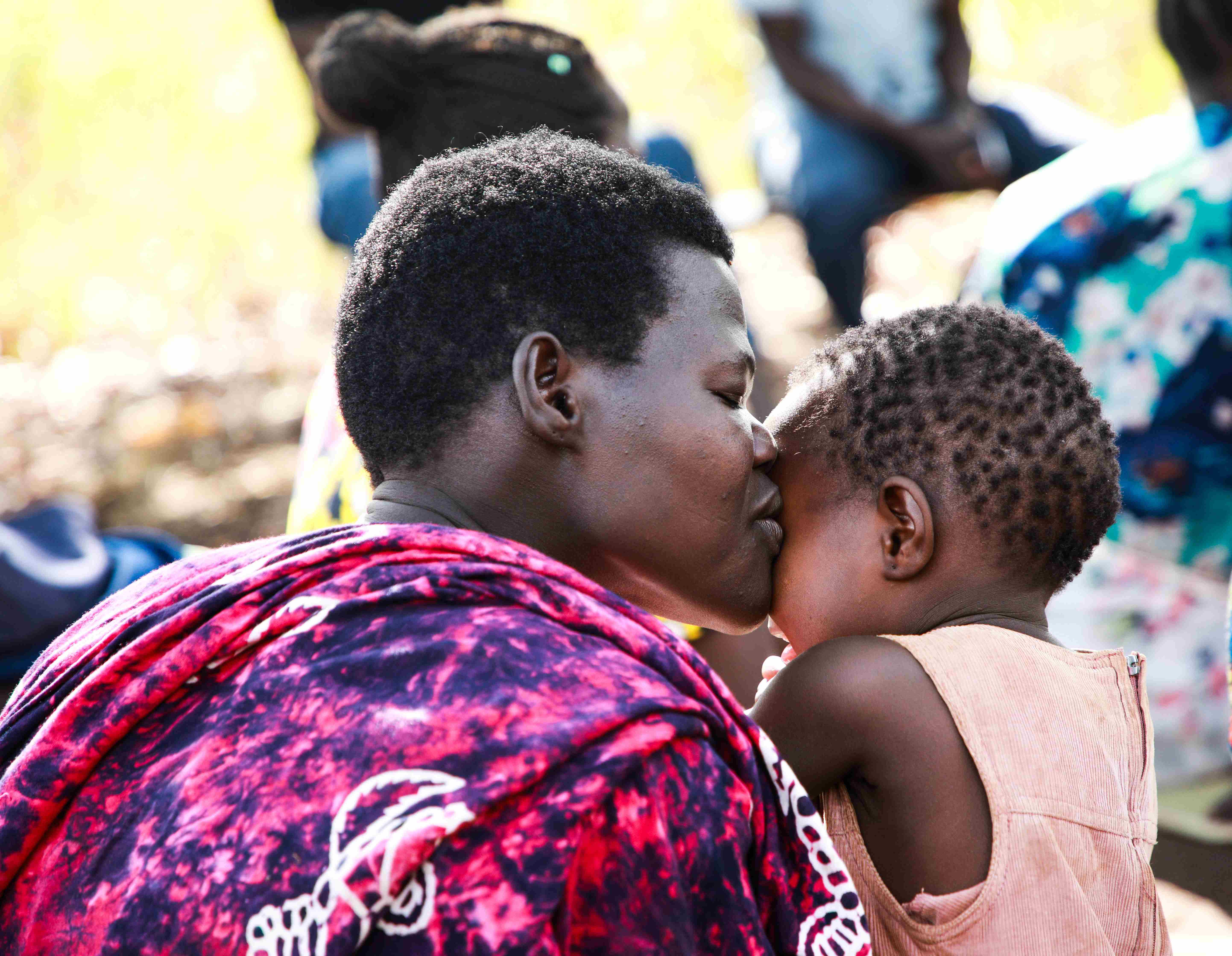 A mother and child at a savings group meeting in Pajule.