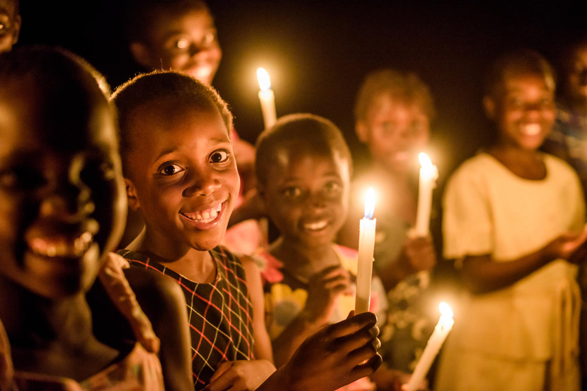 Young children in Zambia standing in candlelight