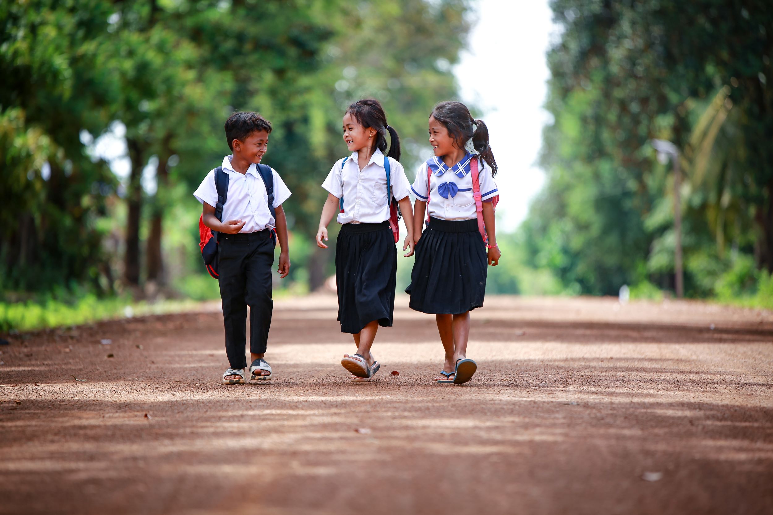 Three children walking to school on their first day