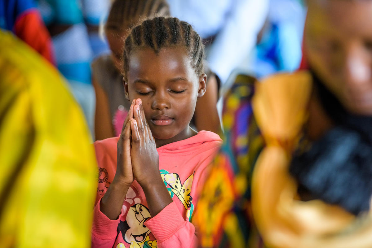 Child praying with her hands together