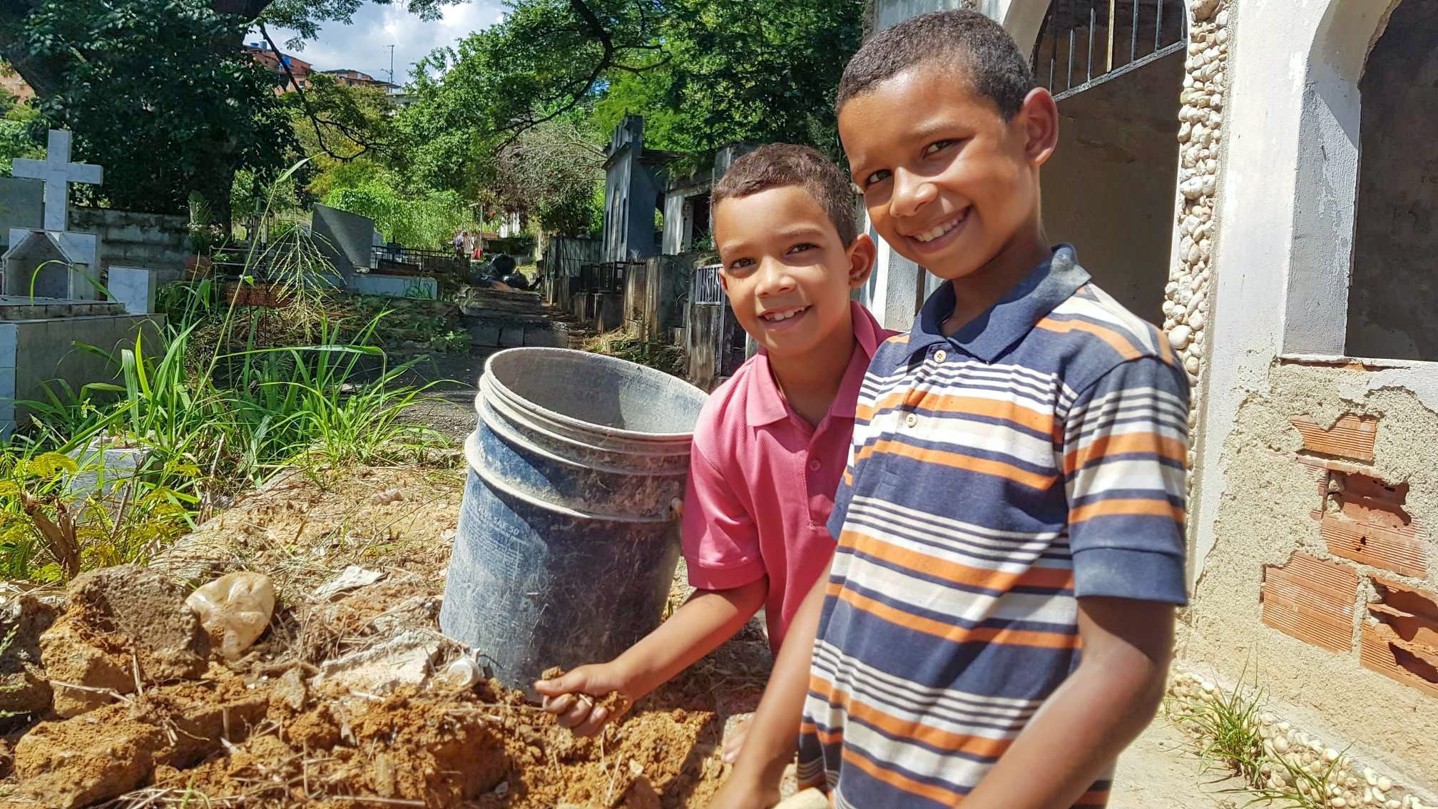 Luigi, 9, red shirt, and his brother, Luis Fernando, 11, at the cemetery