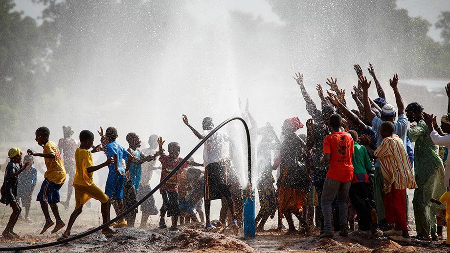 Village in Mali celebrates the arrival of clean water by dancing and raising their arms under the water