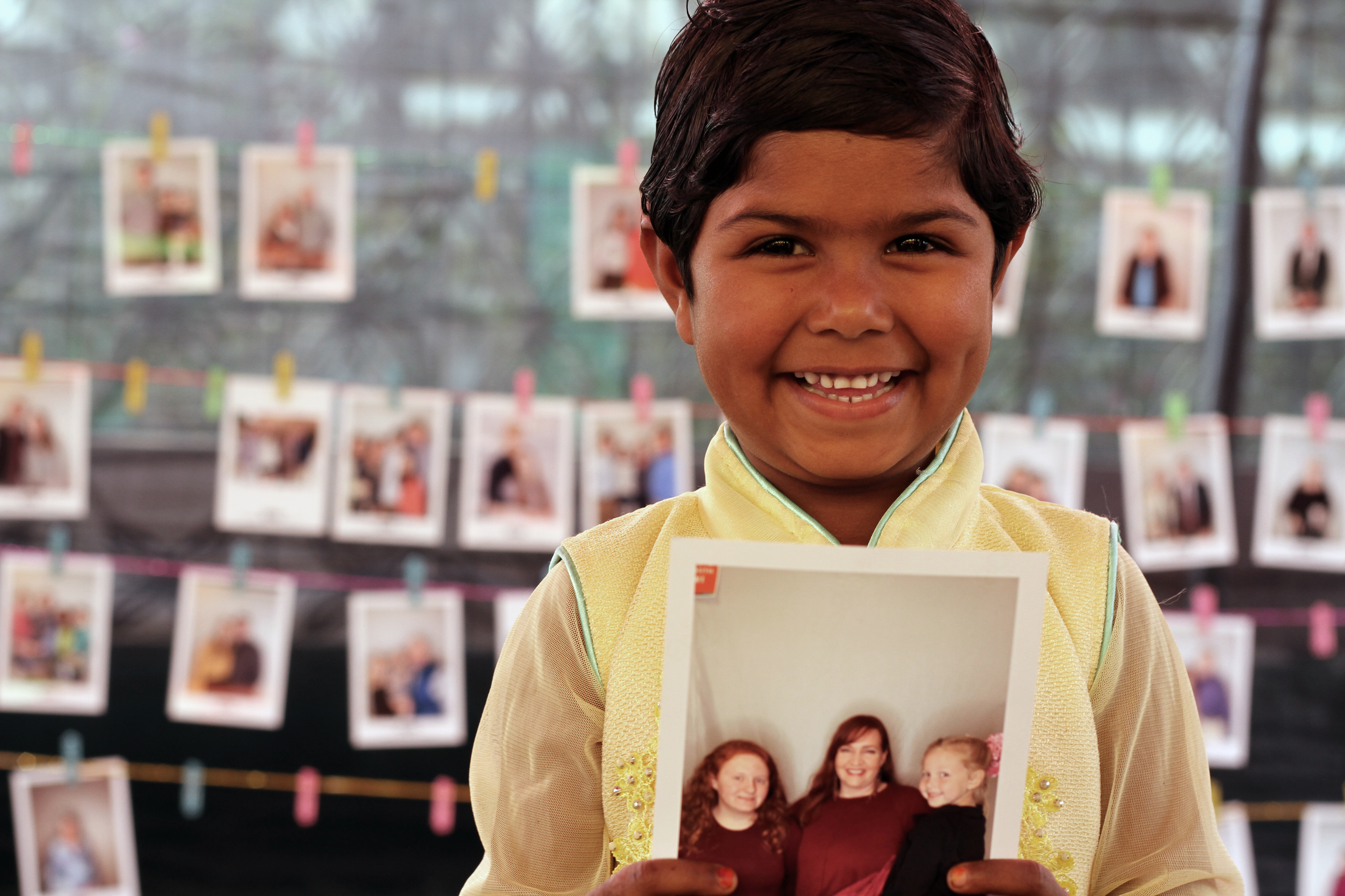 A young girl in Bangladesh beams as she hold the photo of her new child sponsors.