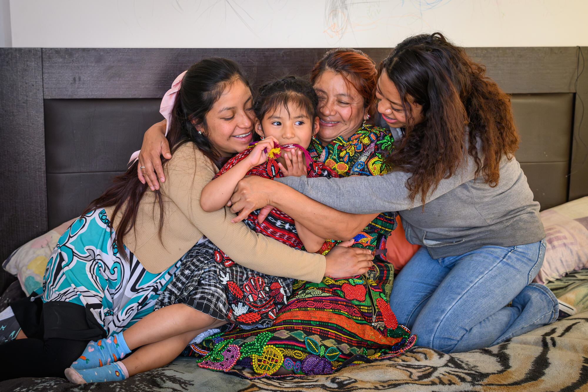 Group hug between a woman and her three daughters in Guatemala