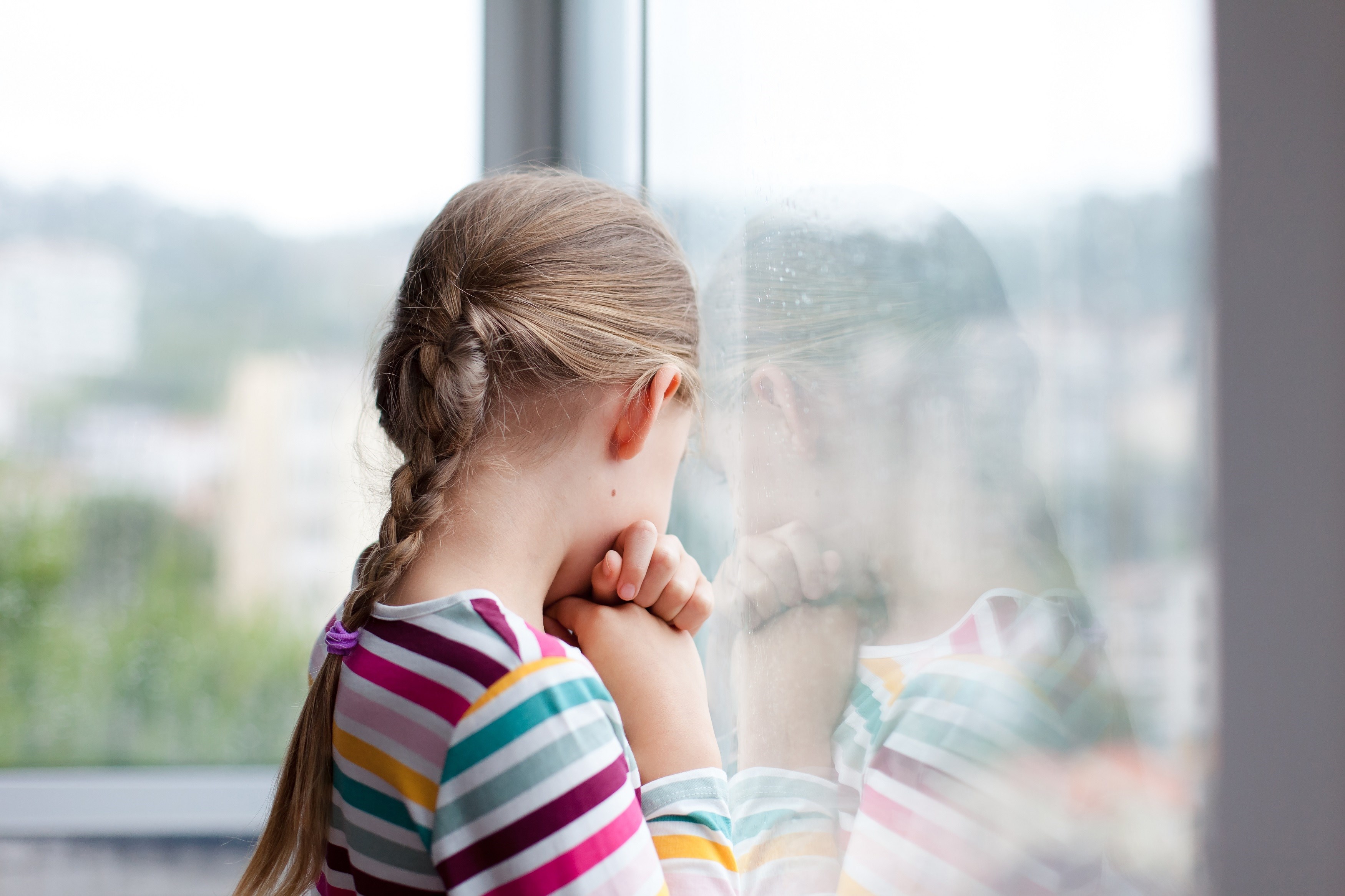 Worried girl staring out the window