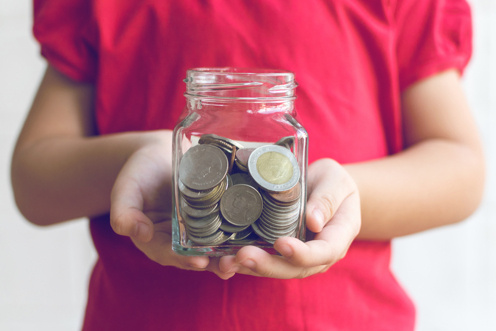 Child holding money in a pot