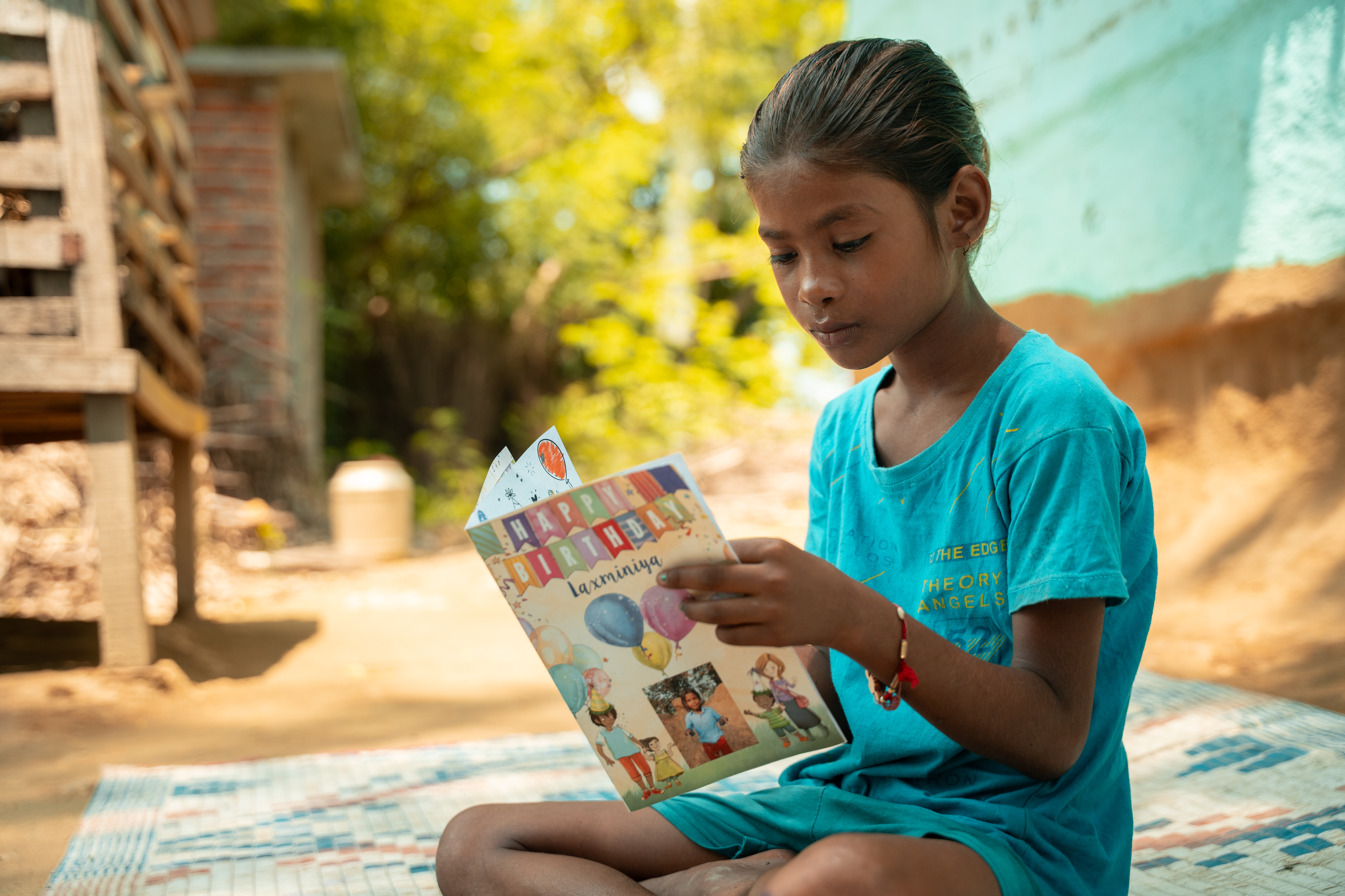 Young girl in Nepal, looking at her birthday card from her sponsor