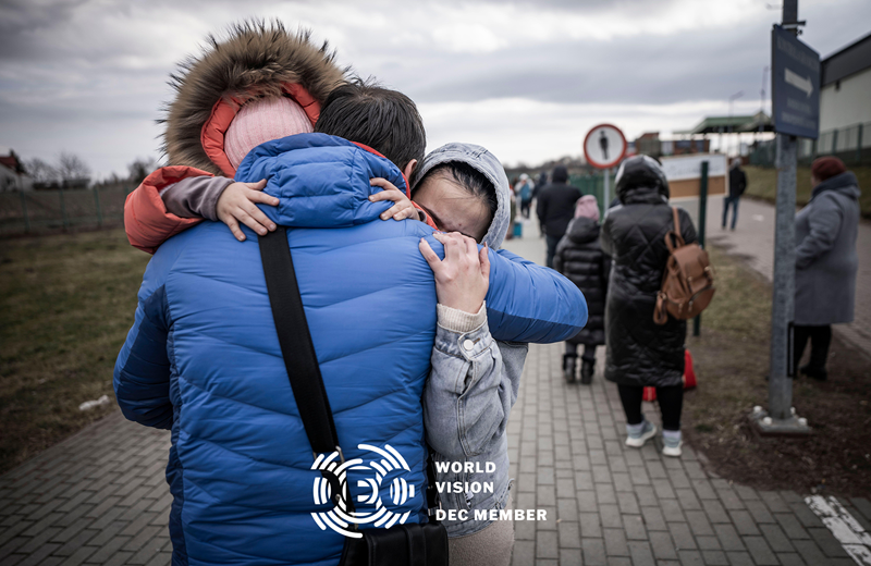 A man hugs his daughter and granddaughter after they crossed the border from Ukraine into Poland