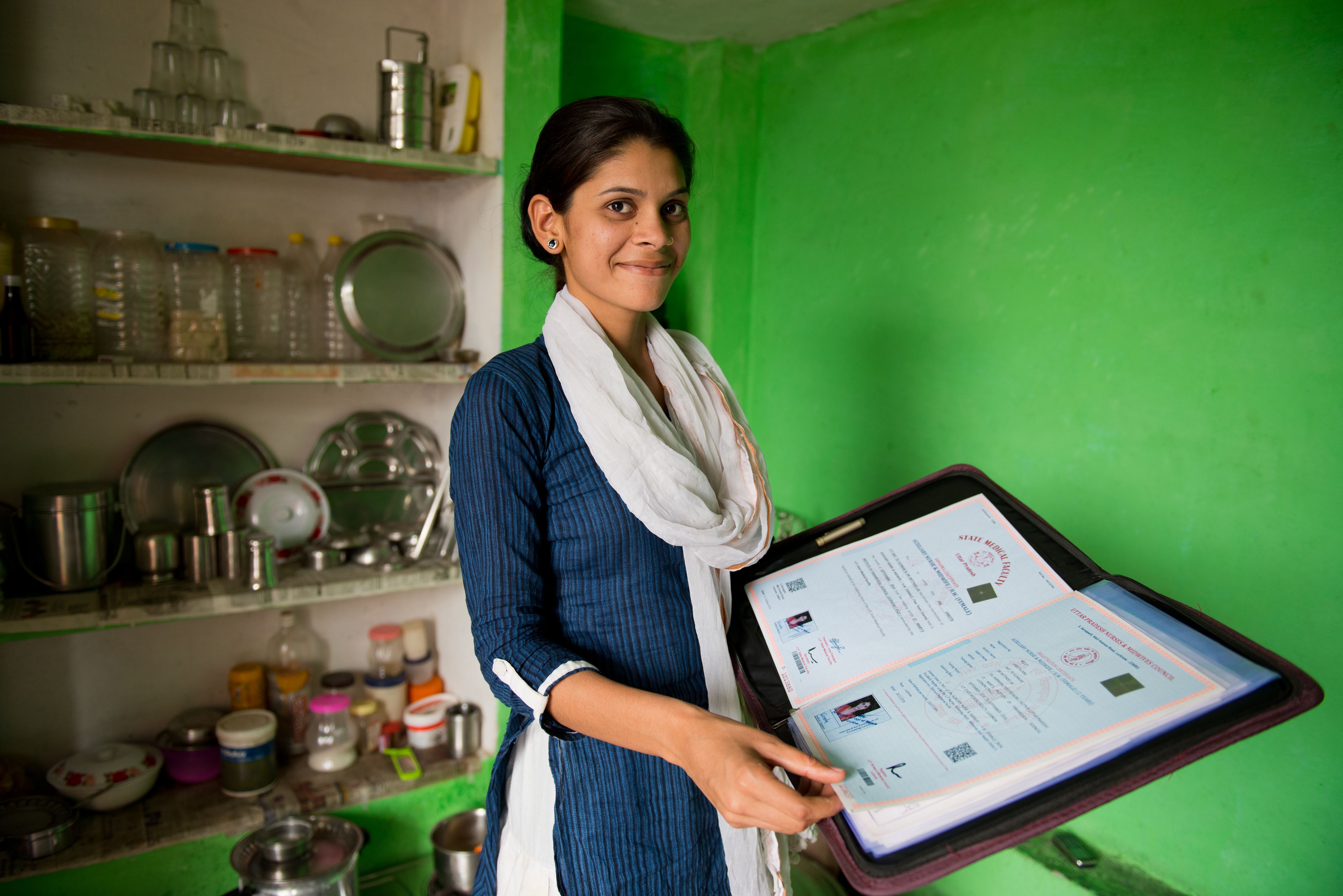 Former sponsored child from India smiles proudly as she shows off her midwifery certificate