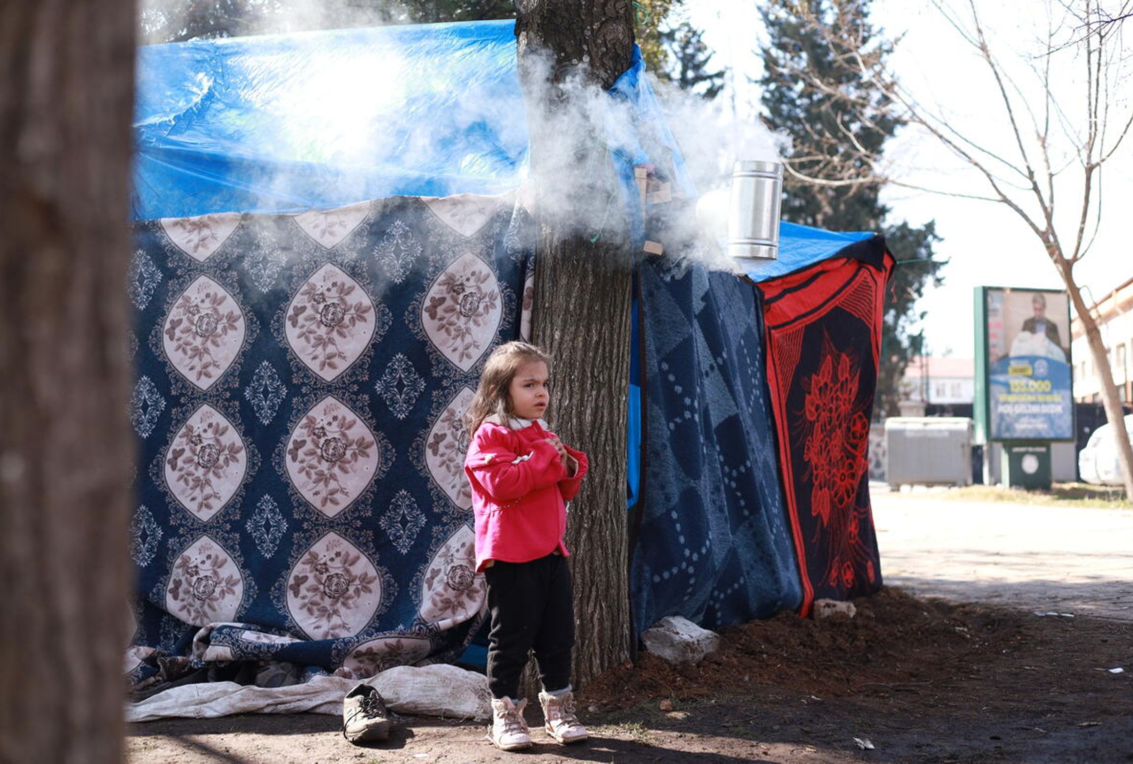 Girl child standing next to temporary shelters in Turkey