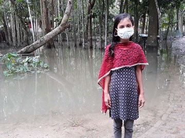 Девушка в Бангладеш стоит посреди наводнения, где раньше была ее деревня
