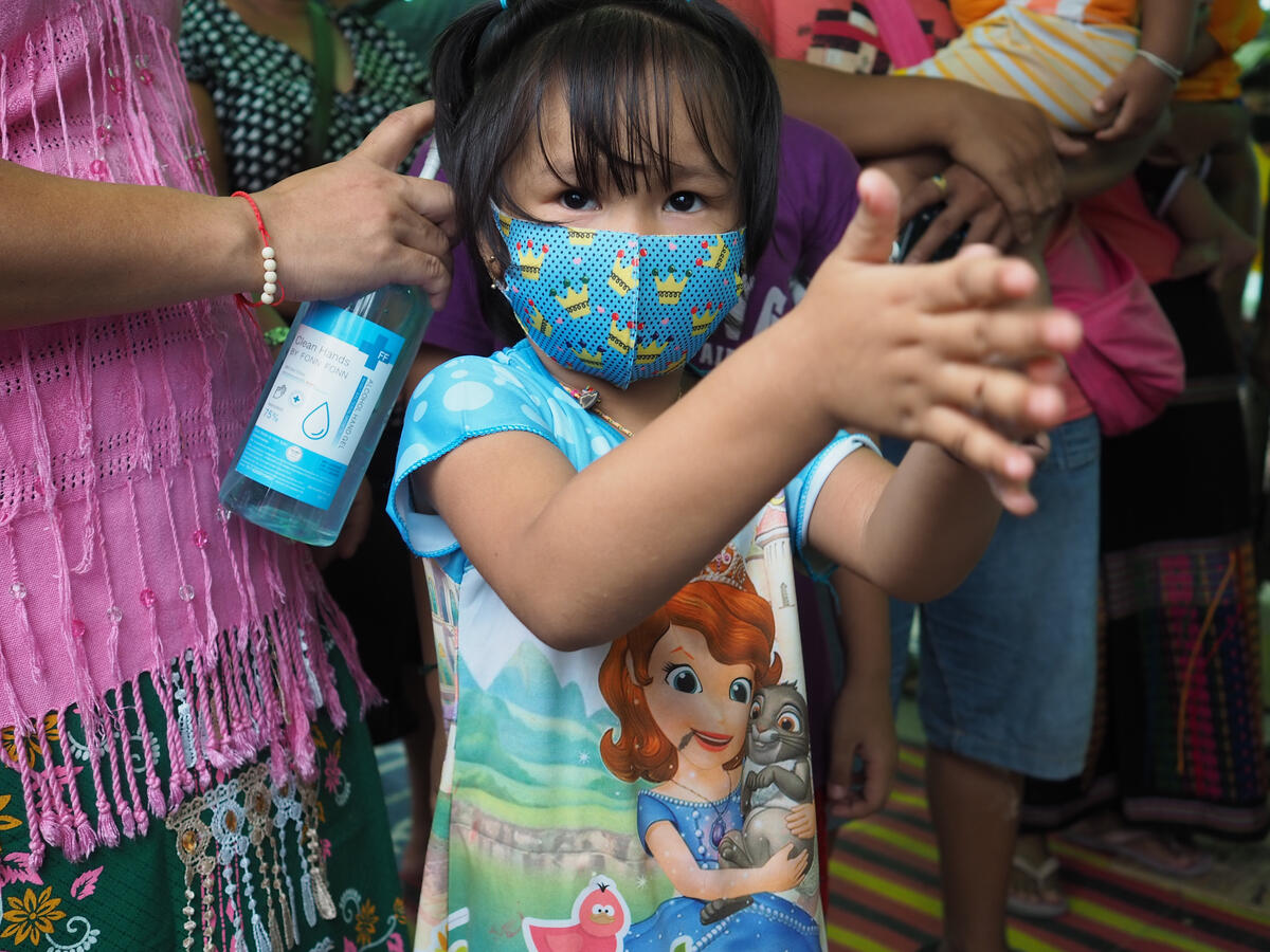 A young girl in Thailand learns how to clean her hands with hand sanitiser to protect from coronavirus