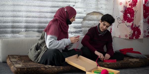  Syrian teenage boy and mother sharing knitting skills