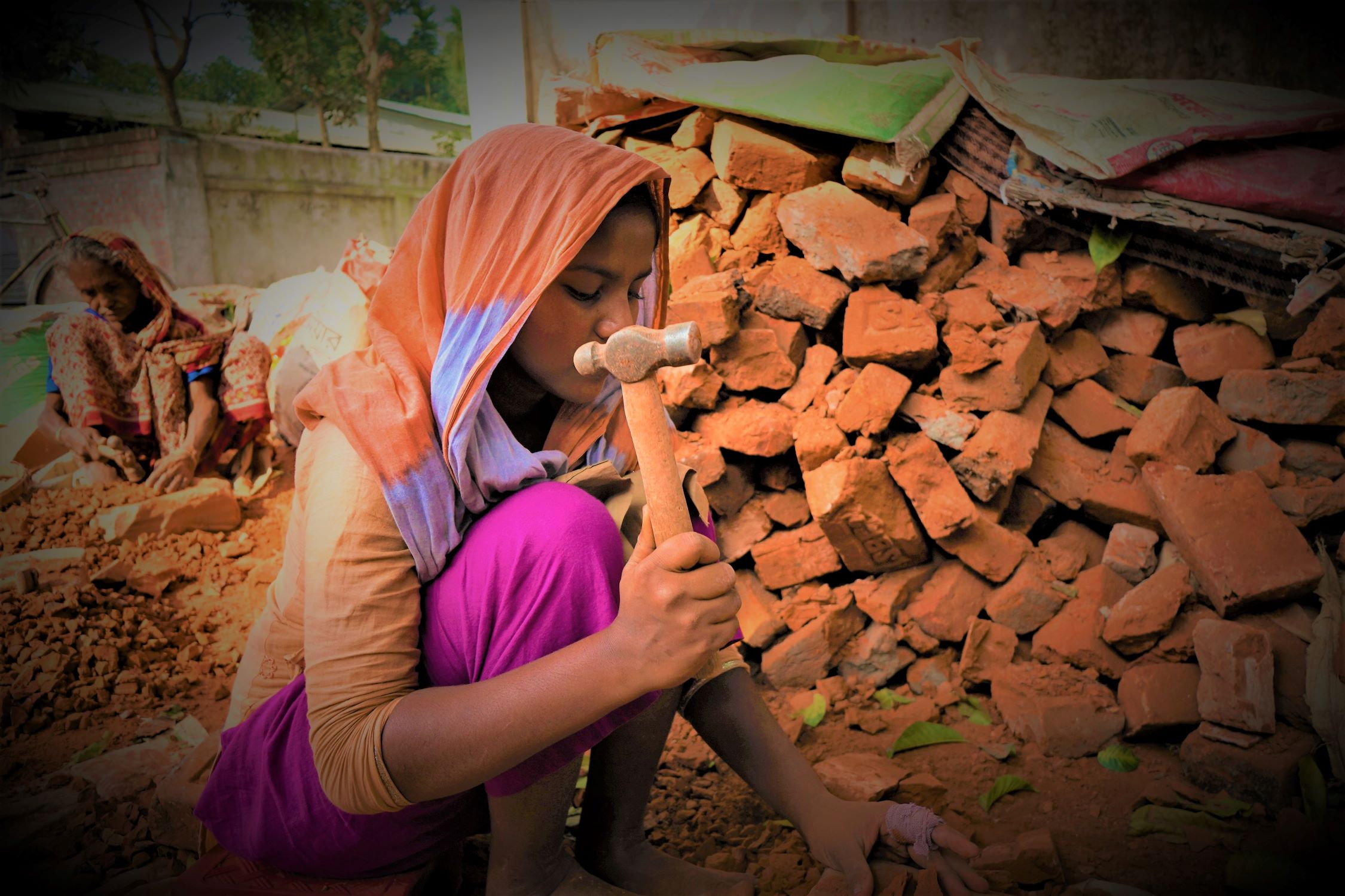 Child labourer breaking bricks