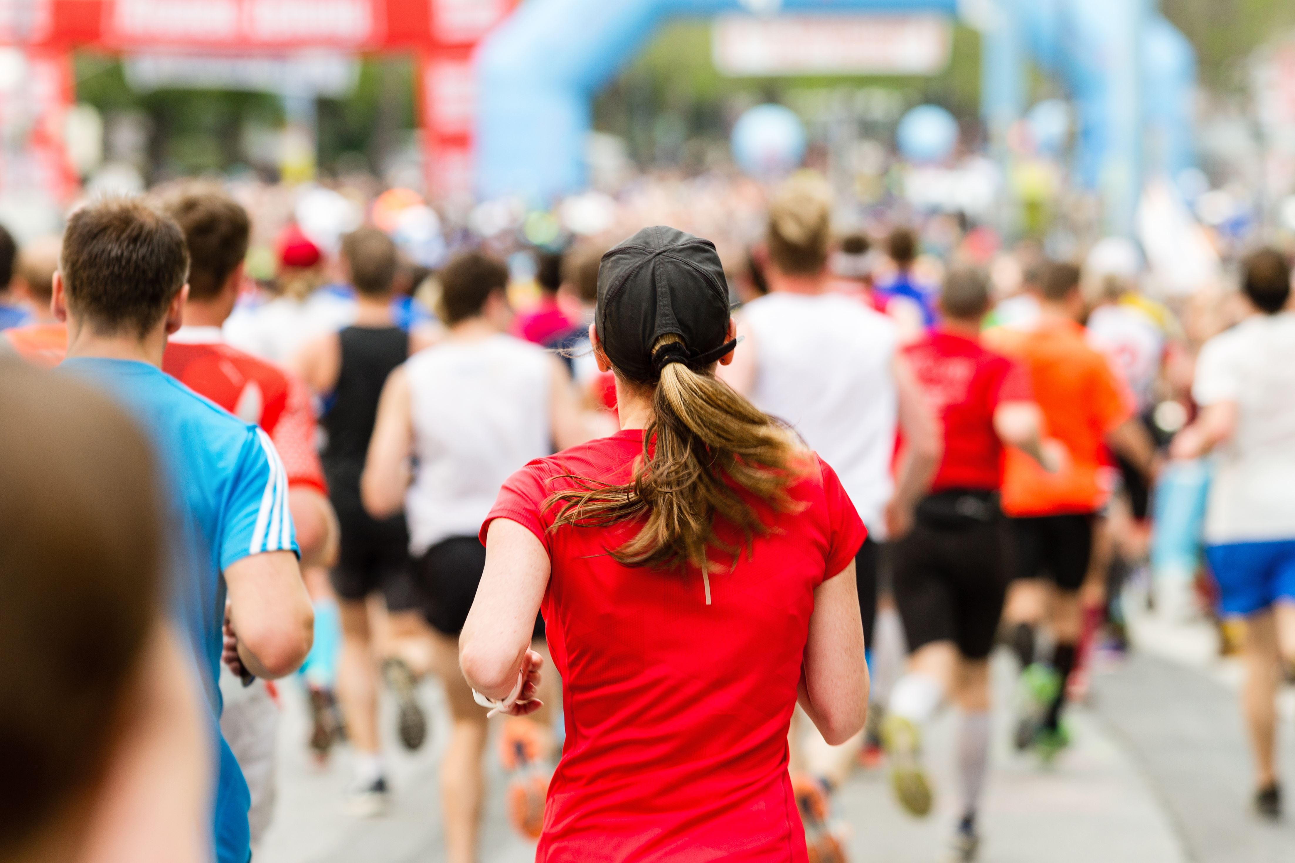 The back of a person running a marathon in a group