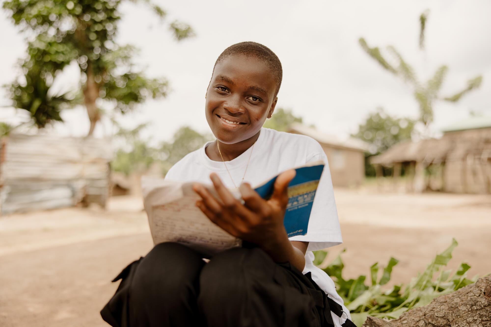 Princess sits with a book in her hands, smiling to camera
