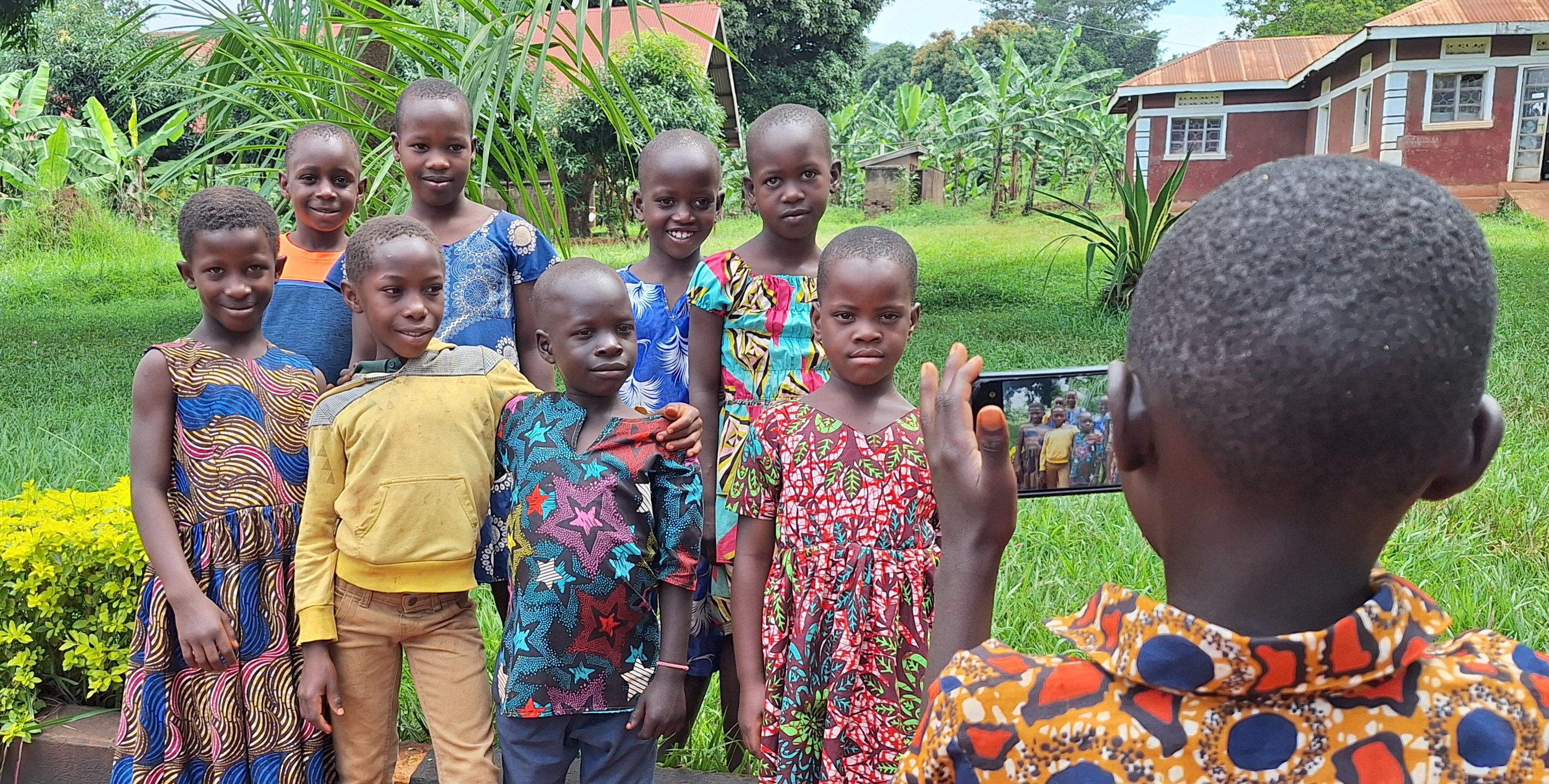 A child in Uganda using a mobile phone to take photos and video of their community