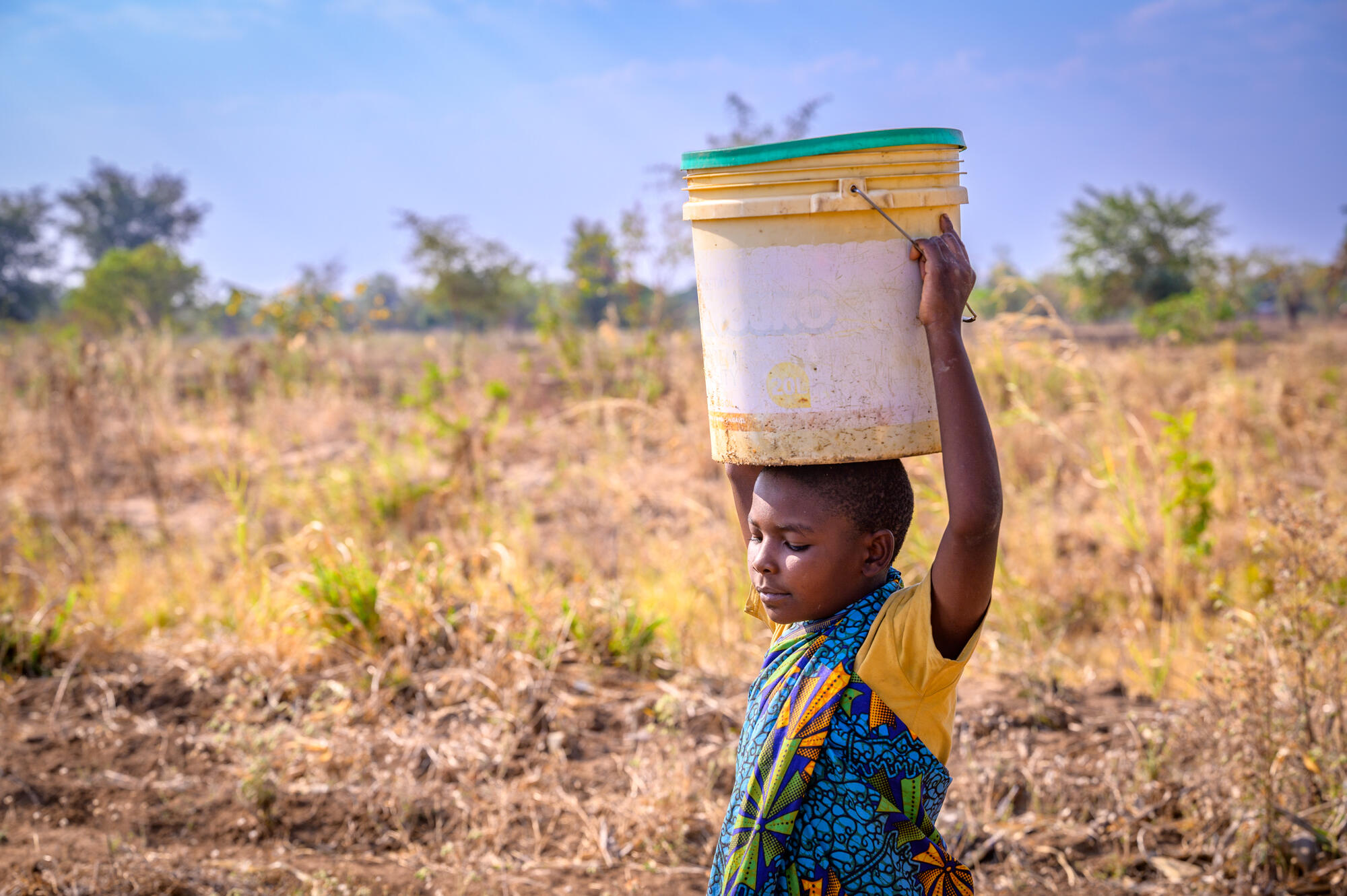 Girls carry buckets of water