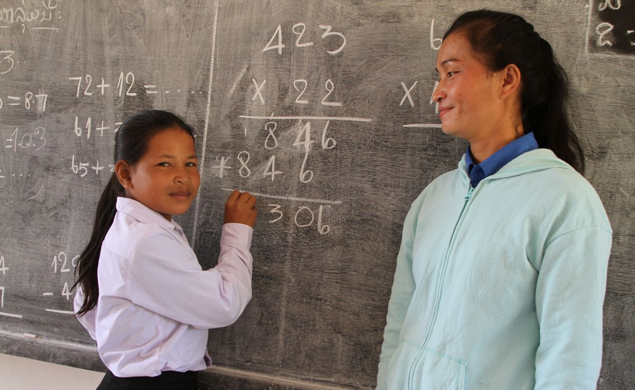 young girl writing on a blackboard 