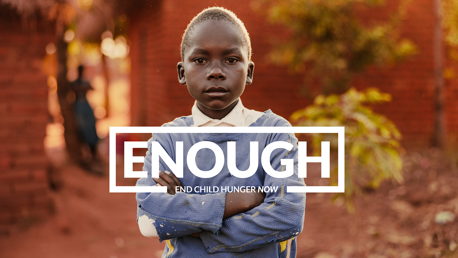 Boy with crossed arms stares directly into the camera