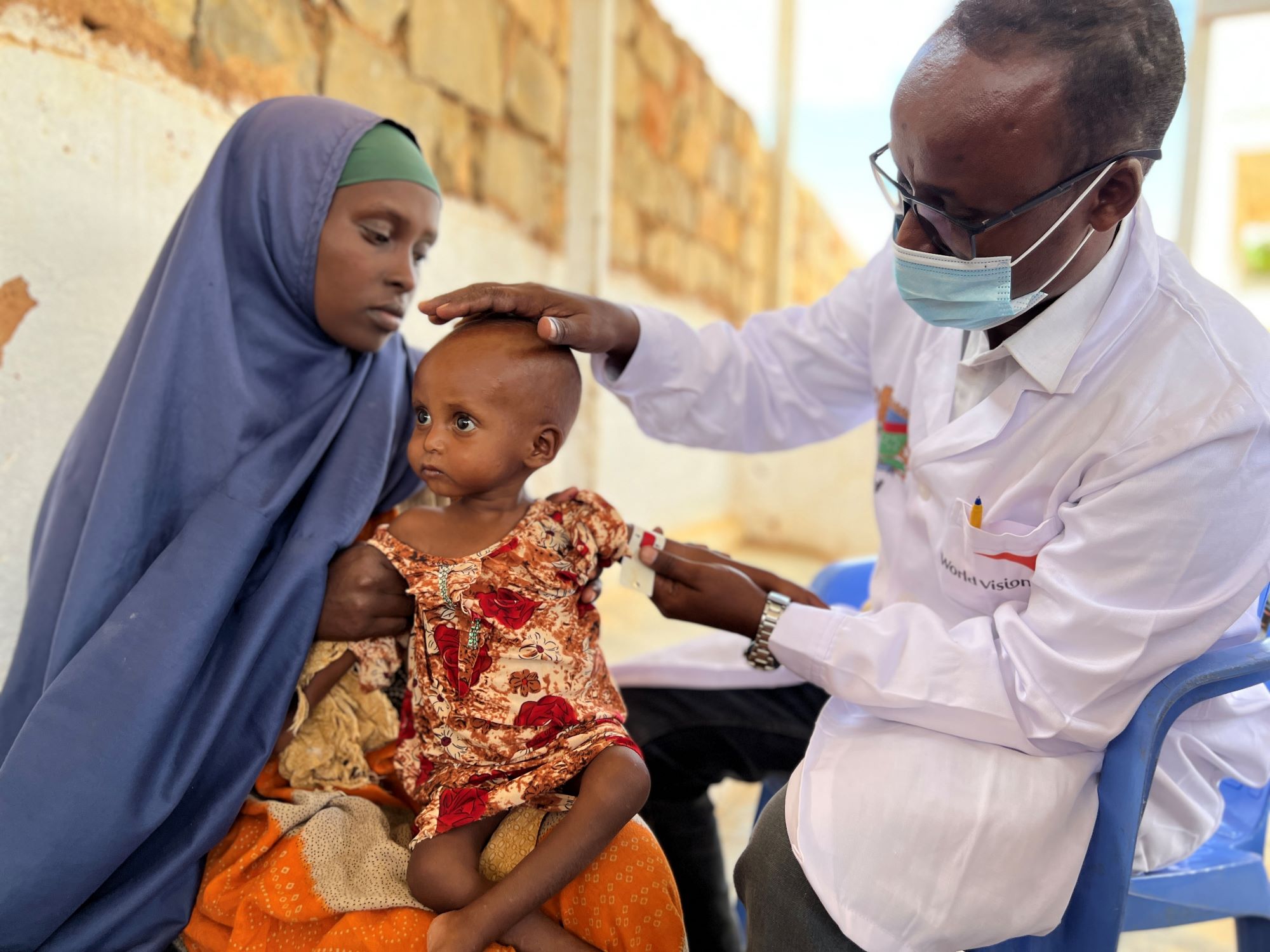 Somalia child being seen by World Vision clinic staff