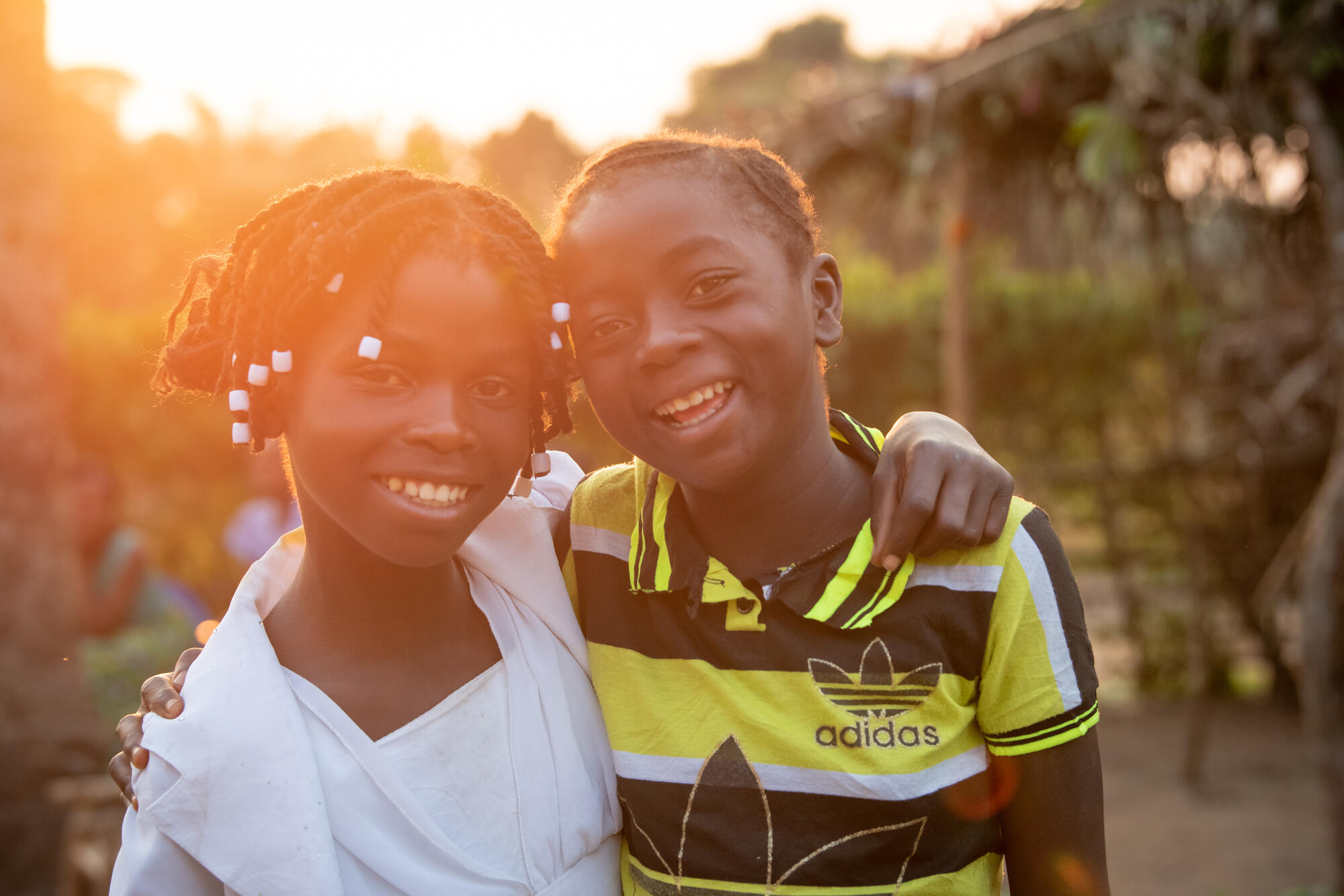 Kapinga Alphoncine, 13-year-old girl (in white) with her best friend, Vicky. Both smile on screen