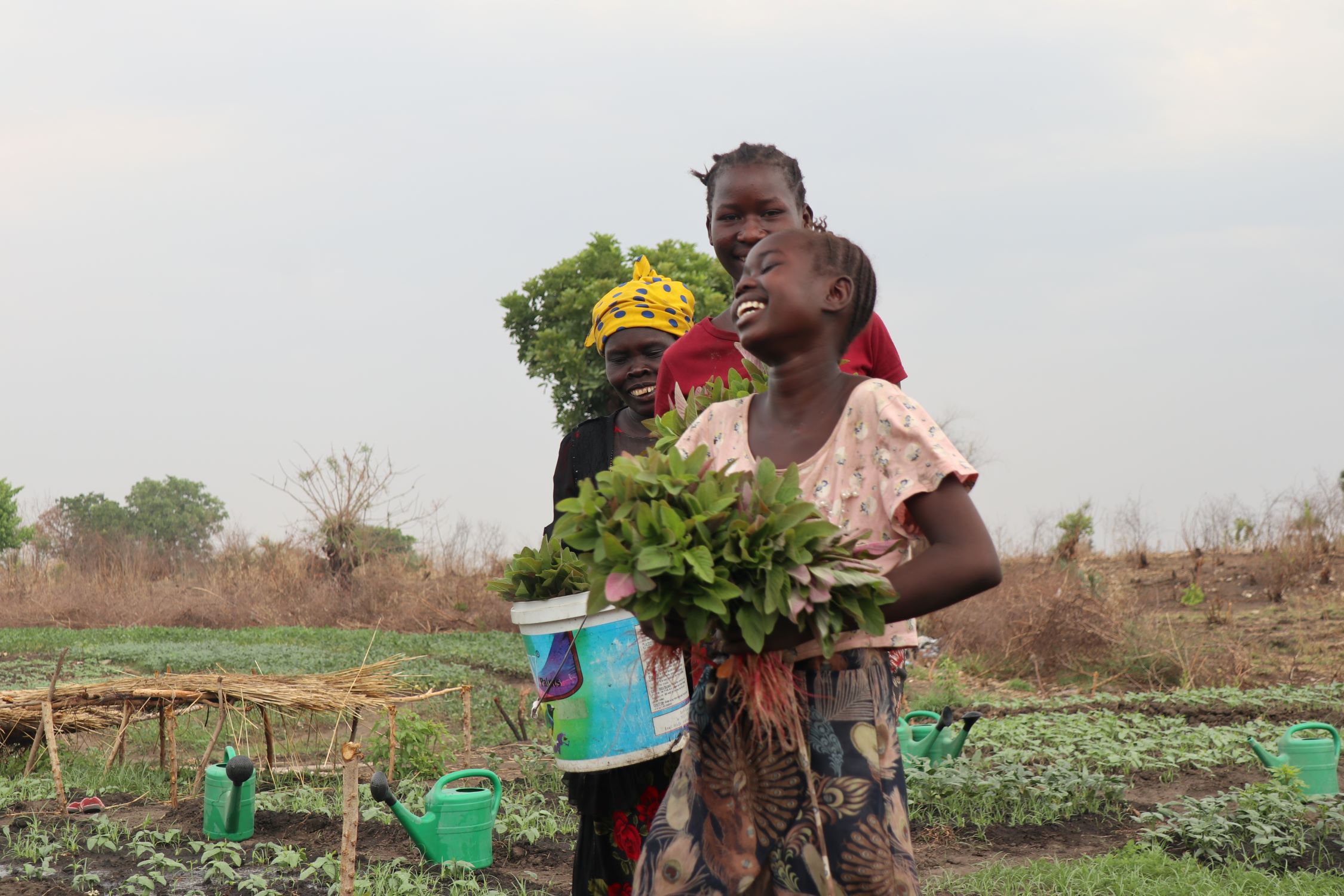 A happy mother and daughters from South Sudan, farming