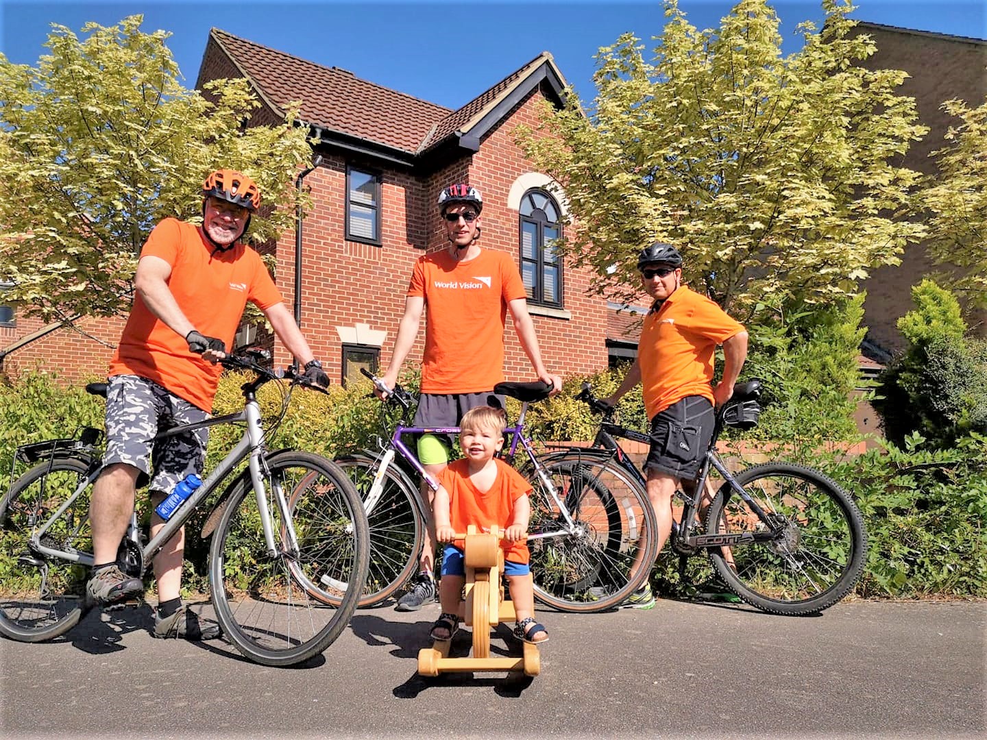 UK family of four pose with bicycles in orange t-shirts to raise funds to protect children from COVID-19