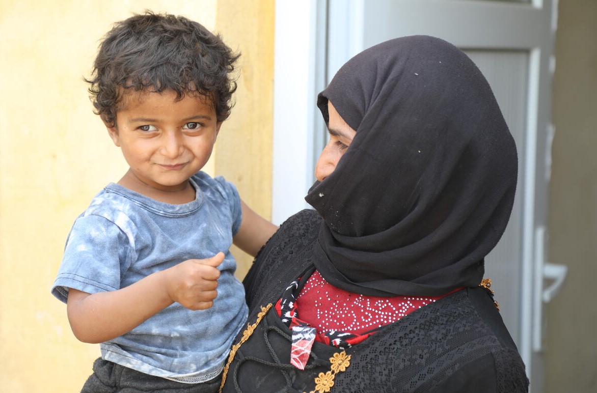 Child from Syria being carried by mother. 