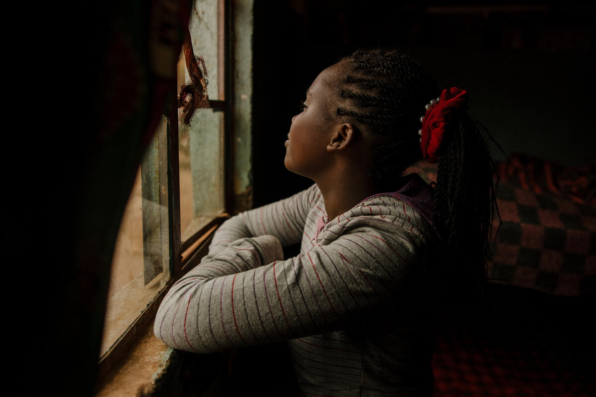 Miriam sits at a window looking out