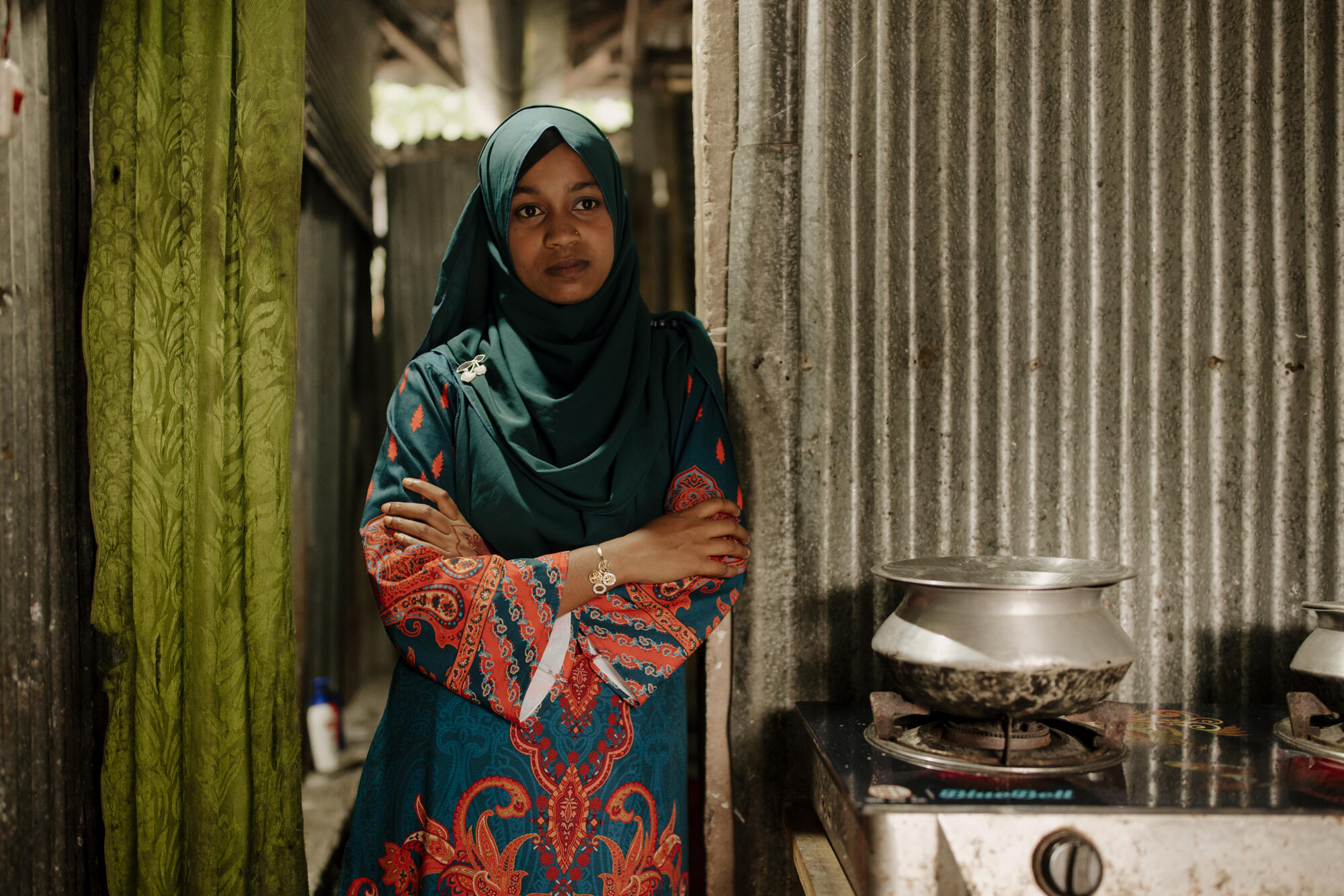 Misu stands by a stove in a home in Bangladesh.