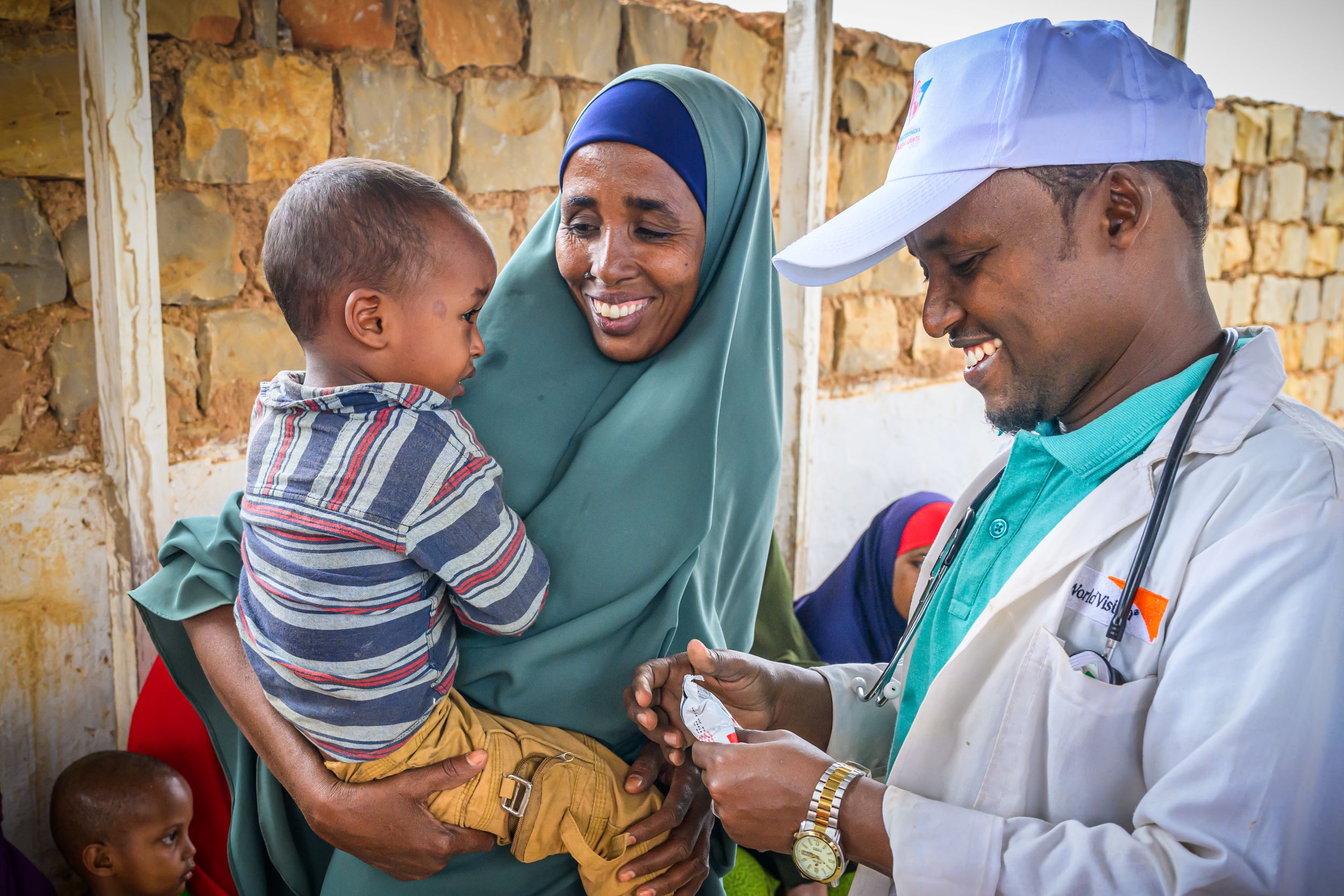 Smiling Somali mother holding her son at a healthcare clinic