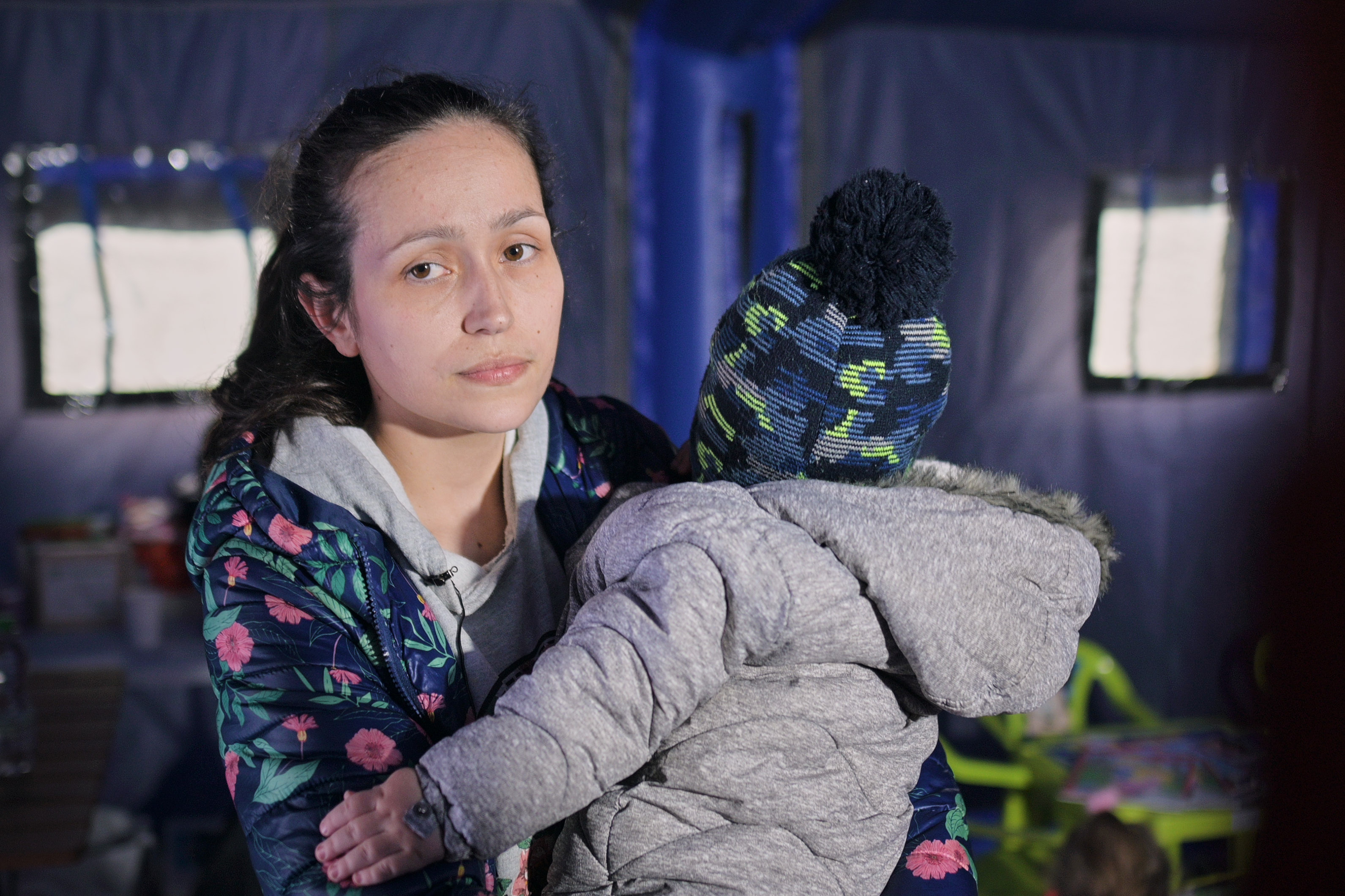 A young girl holding a baby in a child friendly space in Romania