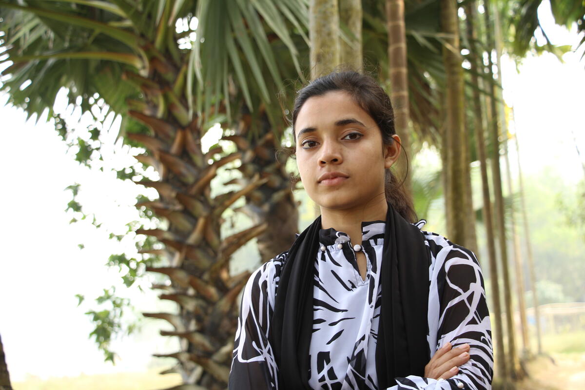 Monika stares seriously into the camera